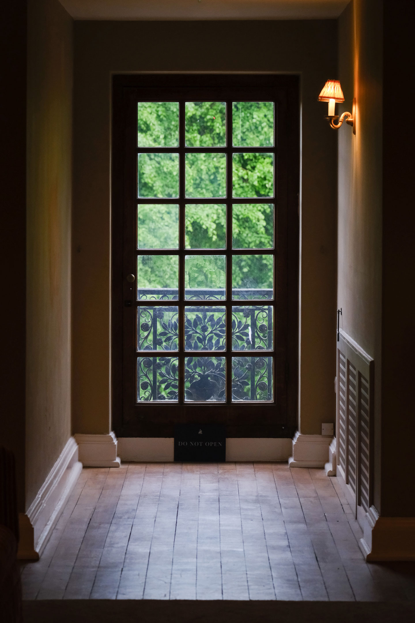 A portrait photo of a full-length window at the end of a wooden hallway, by Amy Moore with a Fujifilm X-T50