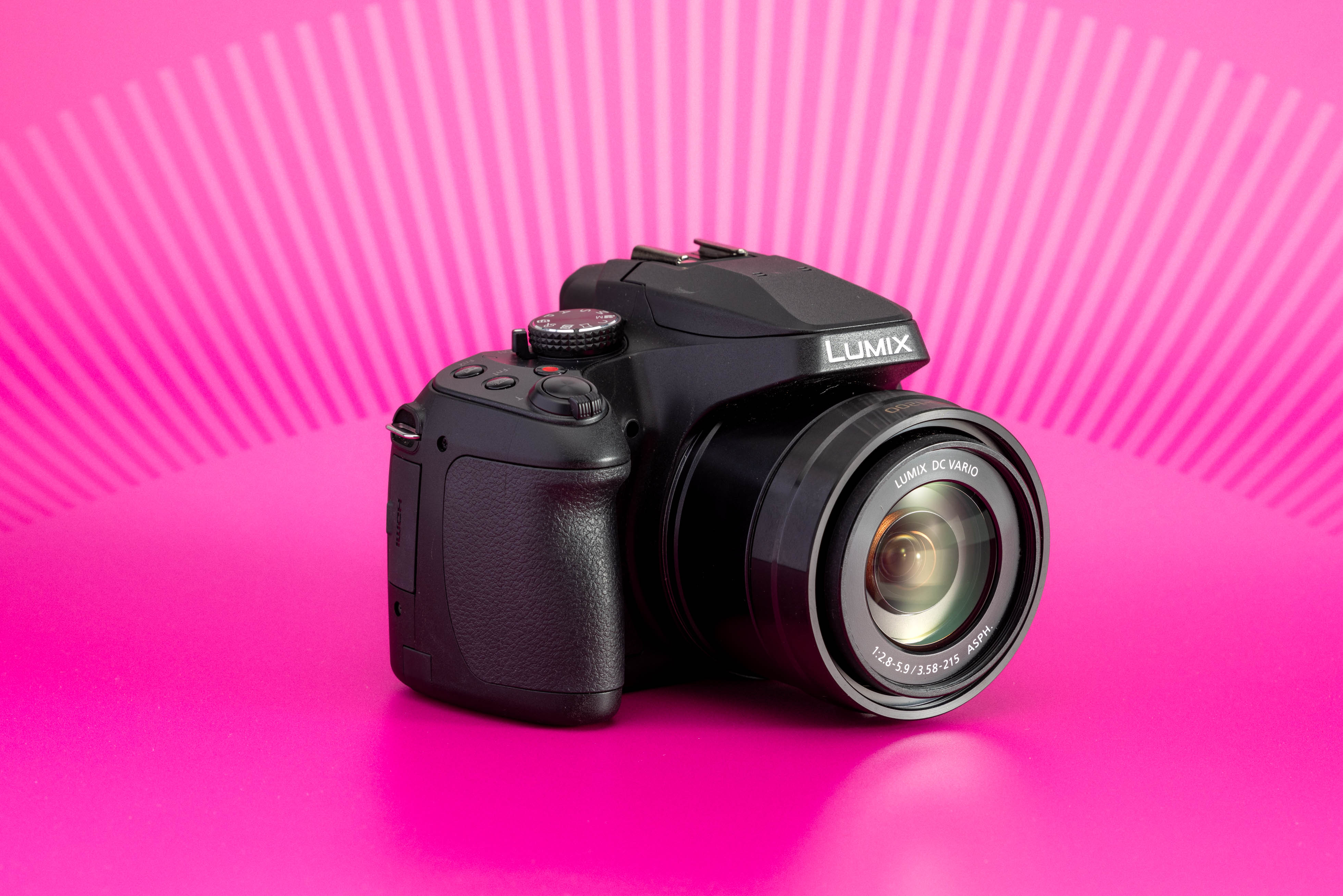 Panasonic Lumix FZ82 fotografiada sobre fondo rosa, con objetivo zoom integrado. Foto de Connor Redmond