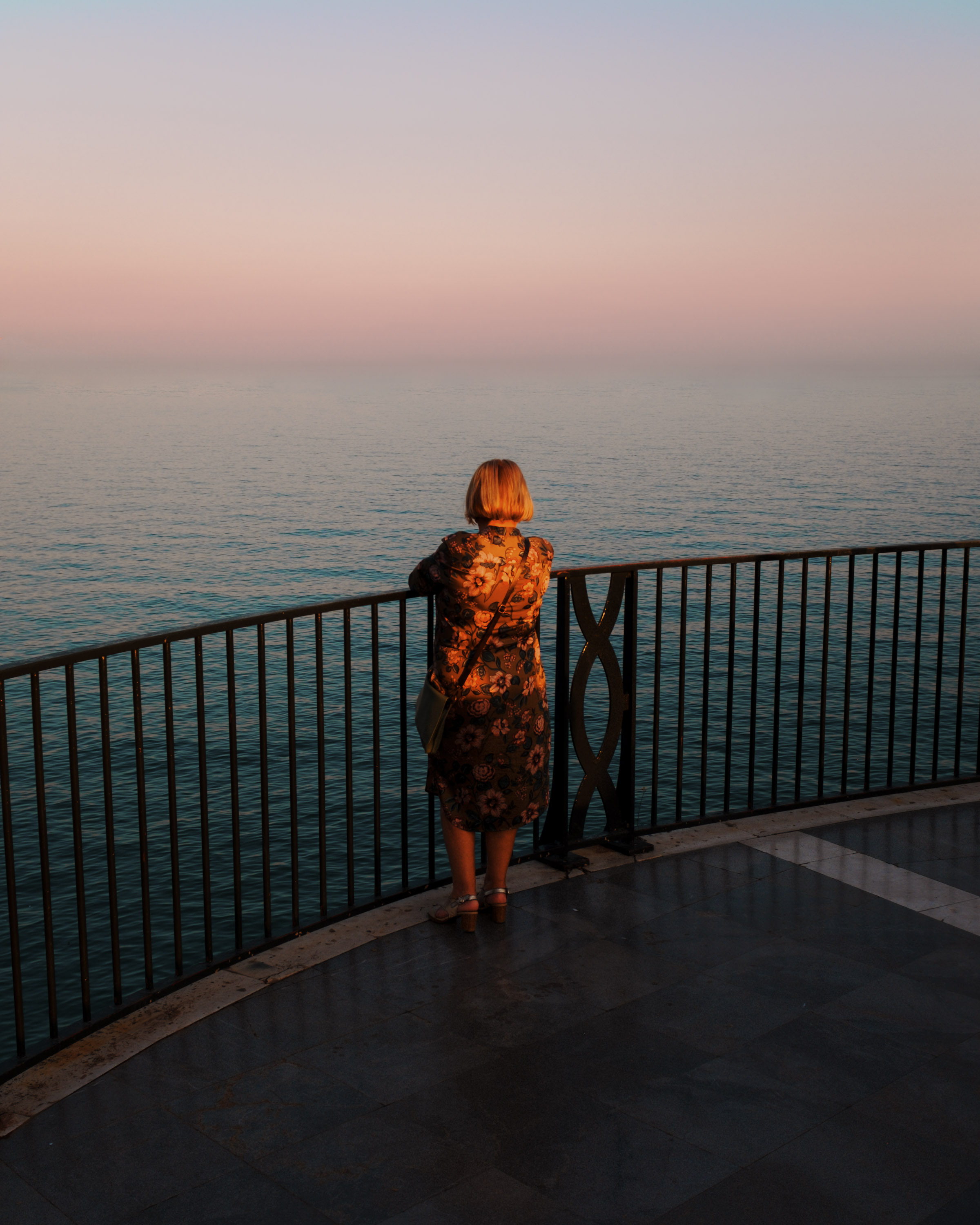A person looks out onto sea at dusk. By Ian Howorth.