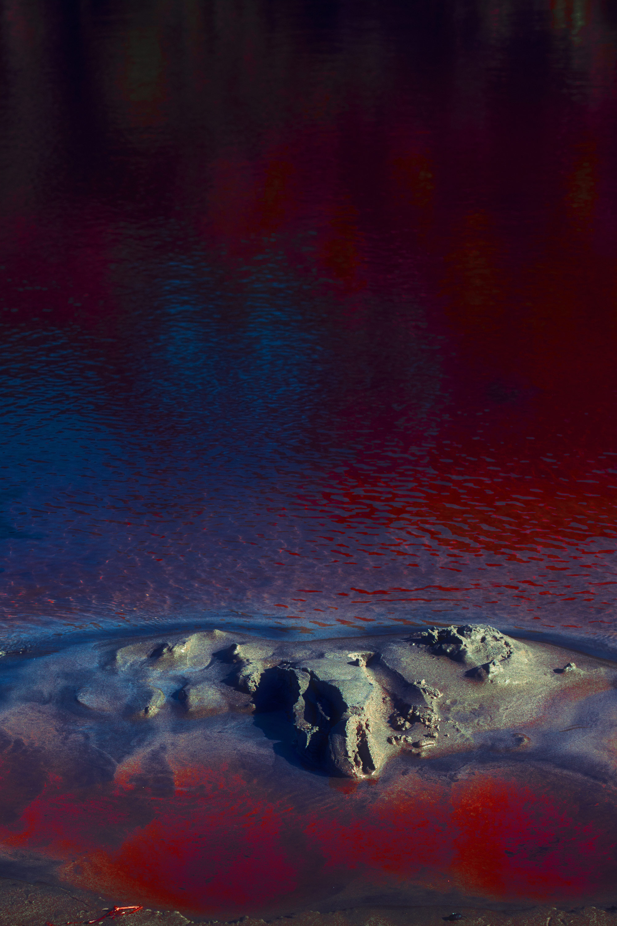 Edited photo of a body of water with strong red-blue tones, shot and edited by Steph O'Connor