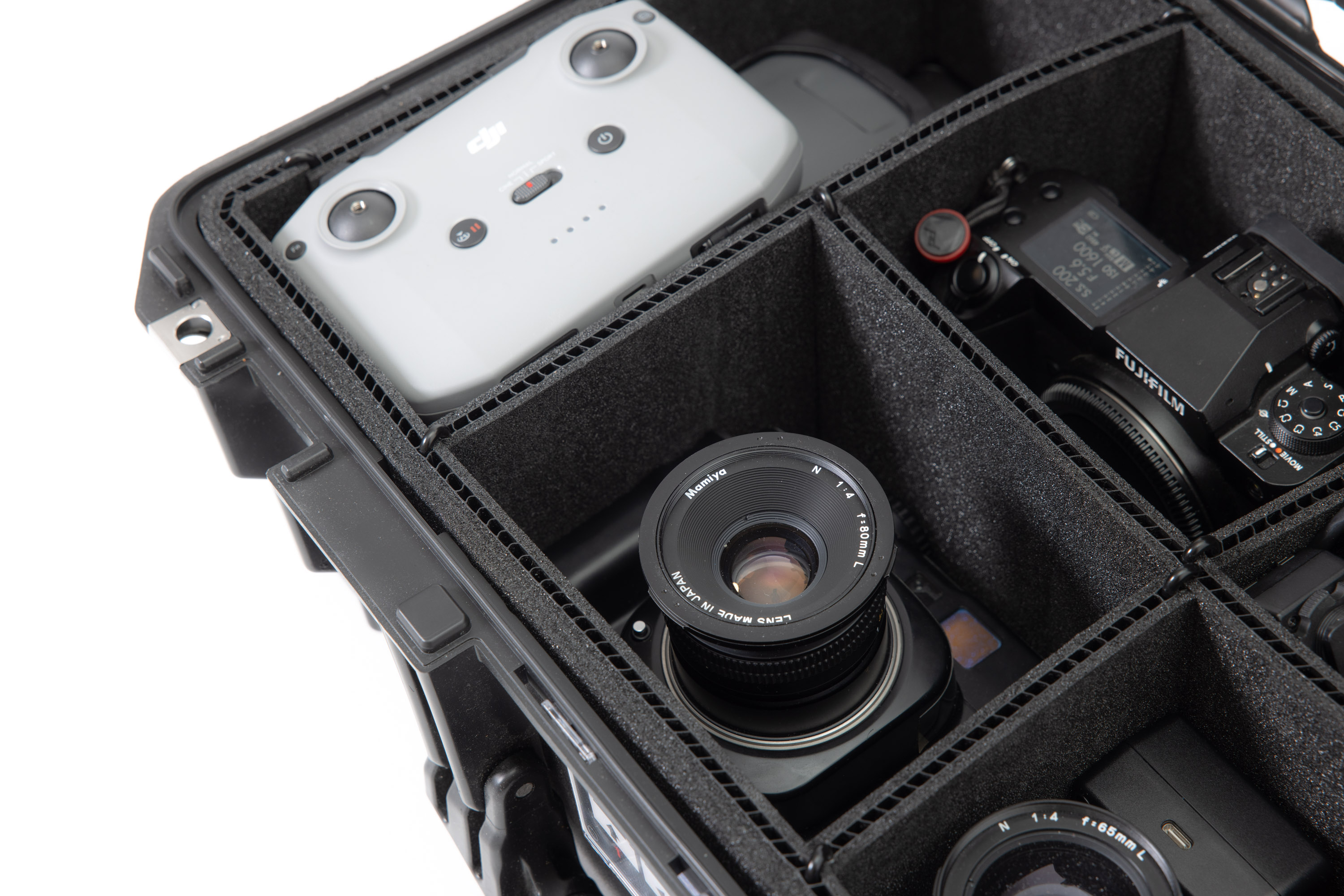 A close-up photo of the Peli 1535 Air Case, showing the TrekPak inserts holding a drone and controller, four cameras and lenses.