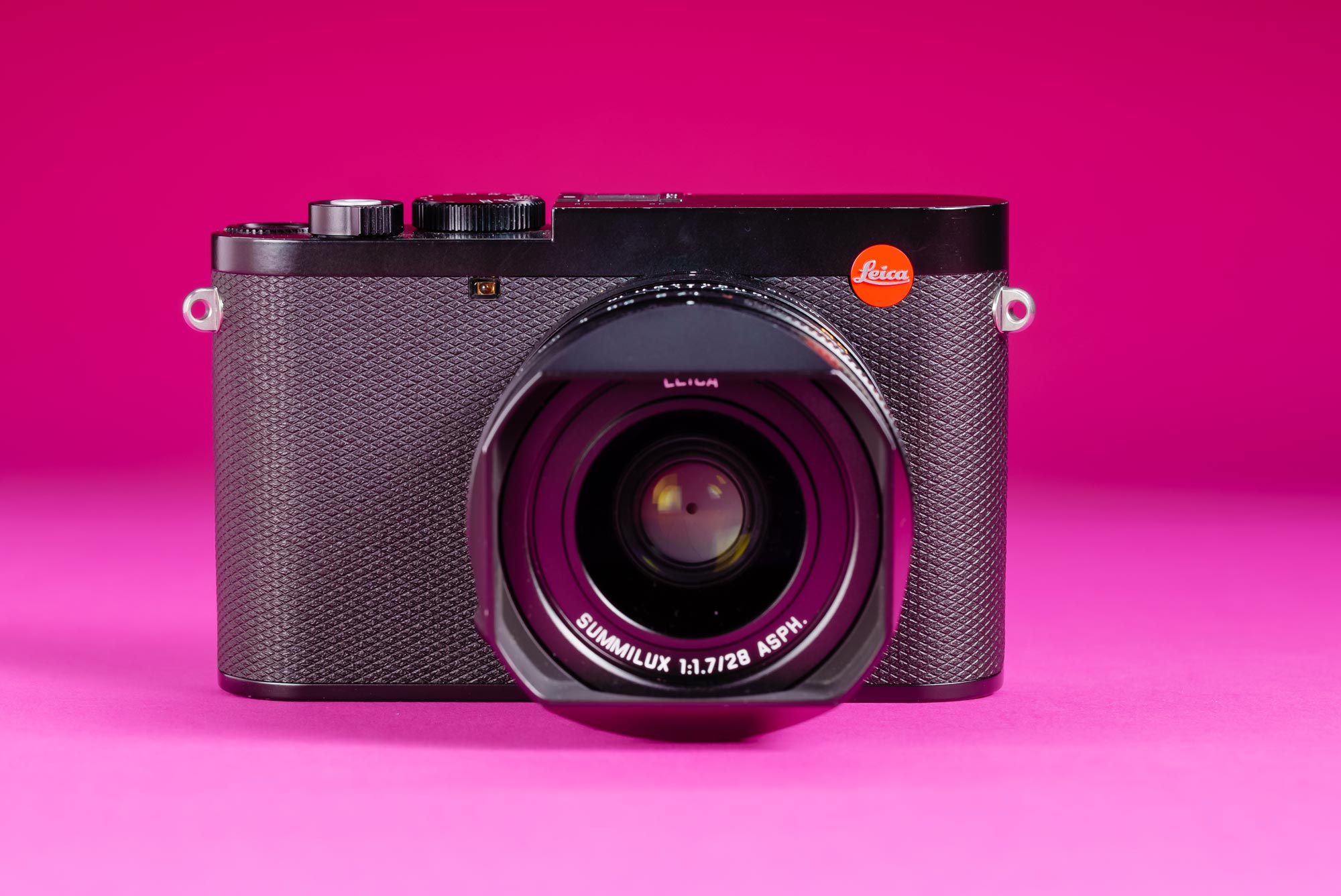 A used Leica Q3 on a graduated pink background.