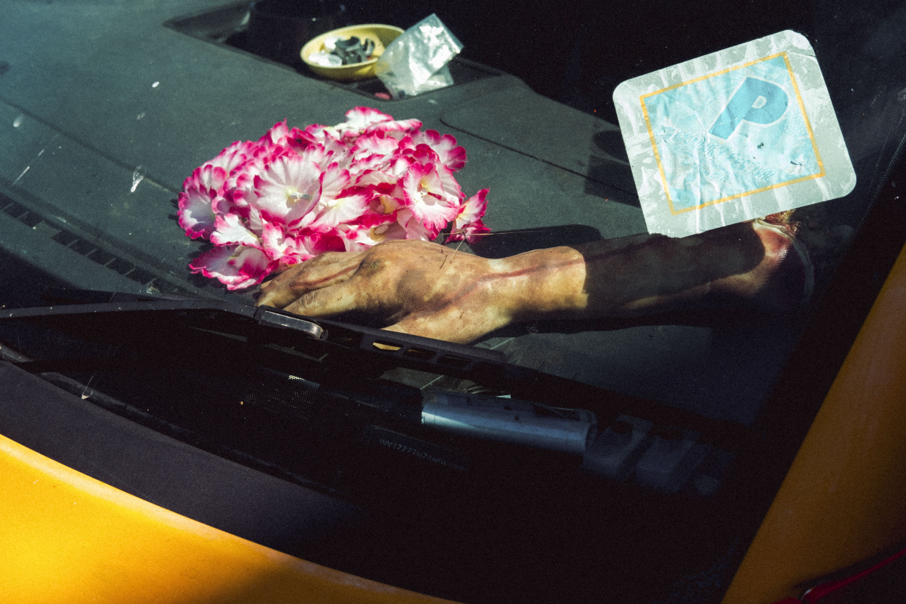 A Yellow car with a fake pink flower and brown Halloween zombie hand. Shot on the X-Pro 3 by Ian Howorth.