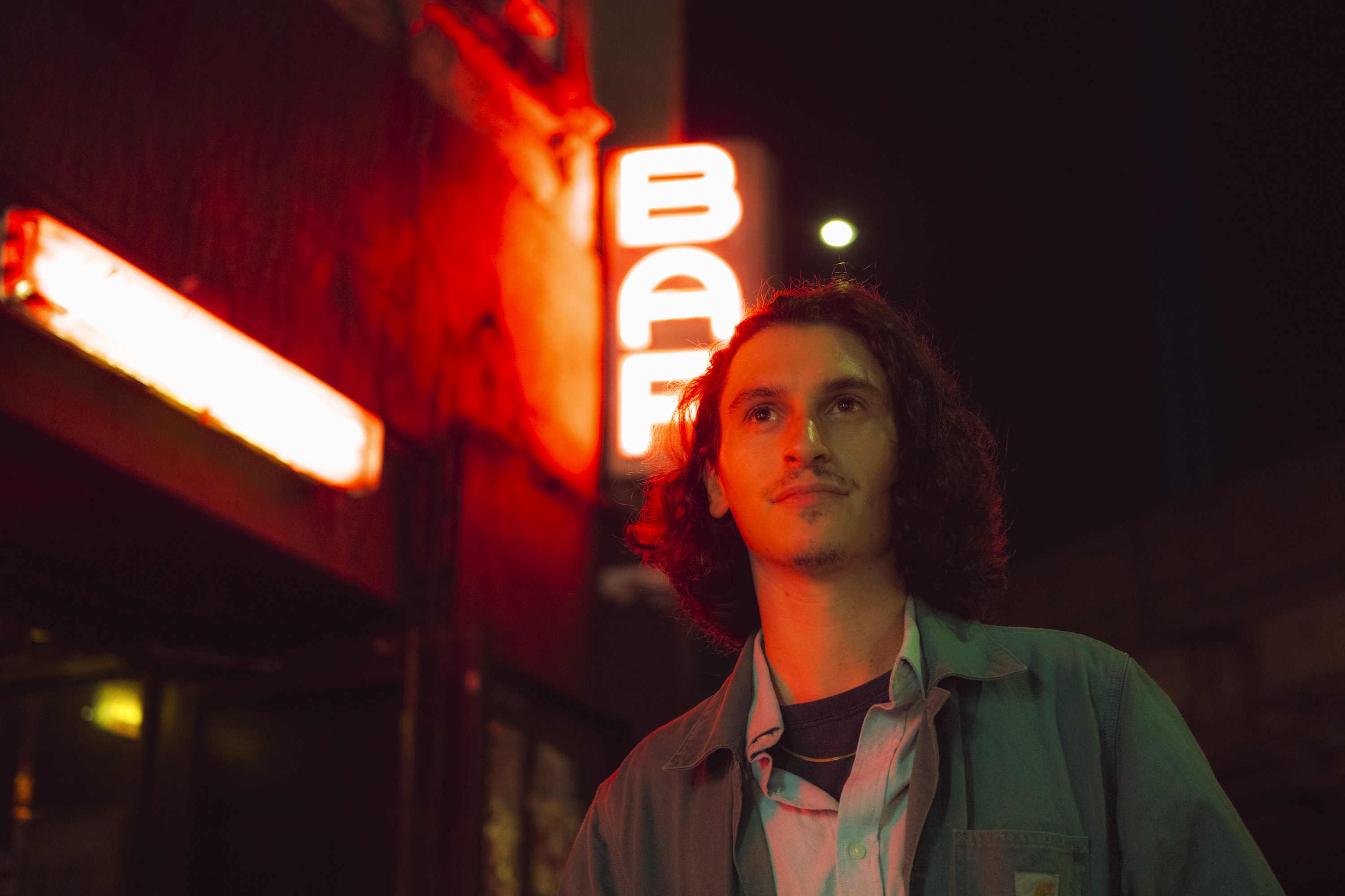 A person in New York at night with a bright red neon light. Shot on the X-Pro 3 by Ian Howorth.