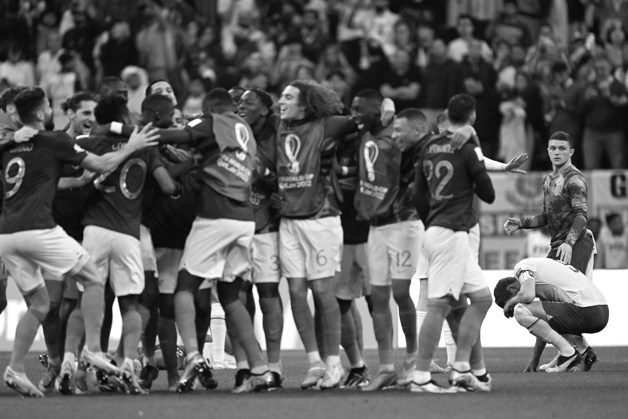 Photo en noir et blanc de l'équipe de France célébrant au premier plan, tandis que les joueurs anglais se consolent à l'arrière-plan, lors des quarts de finale de la Coupe du monde 2022, prise par Ryu Voelkel avec un Nikon Z9.