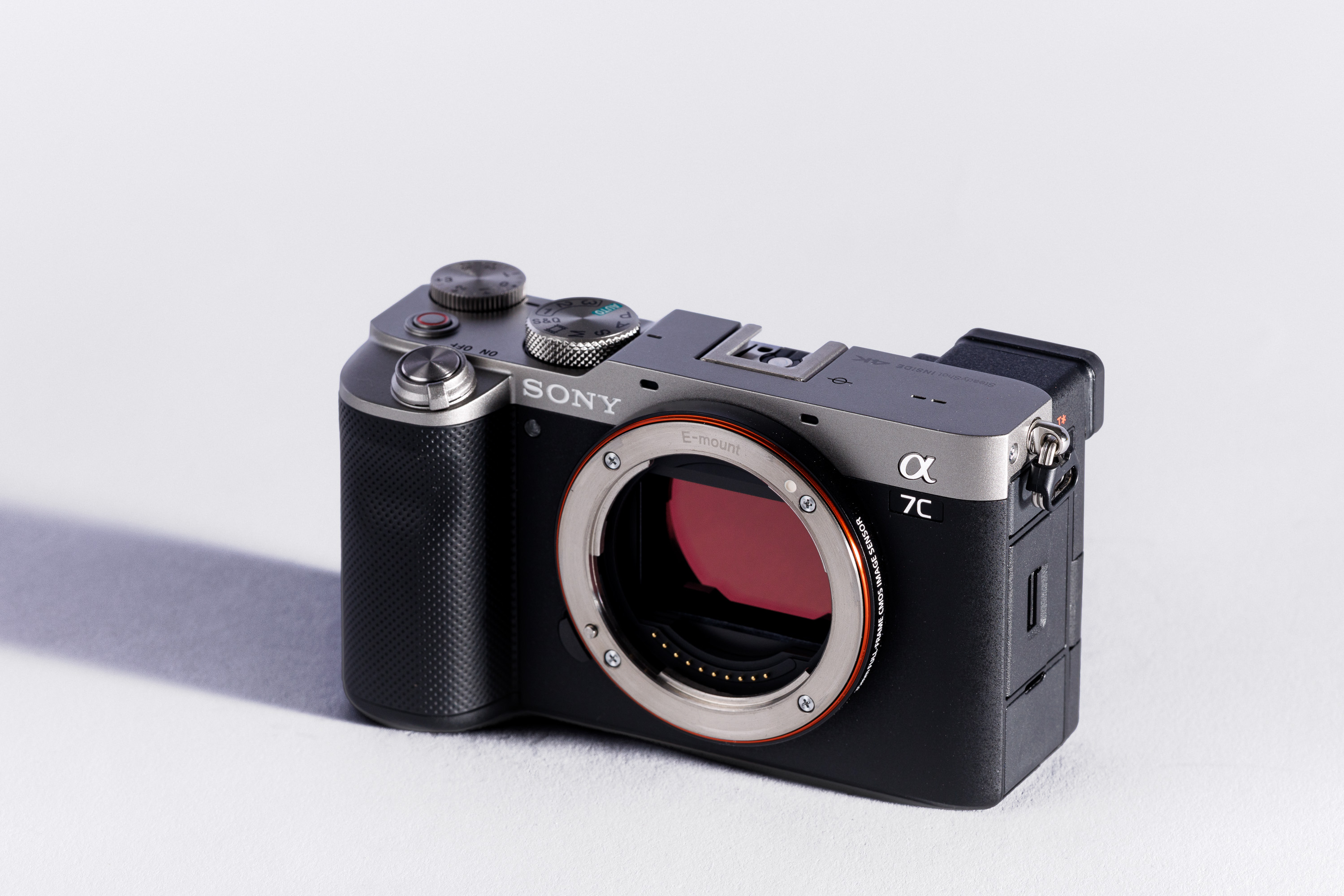 A used Sony A7C body on a white background, with a shadow to the left. 