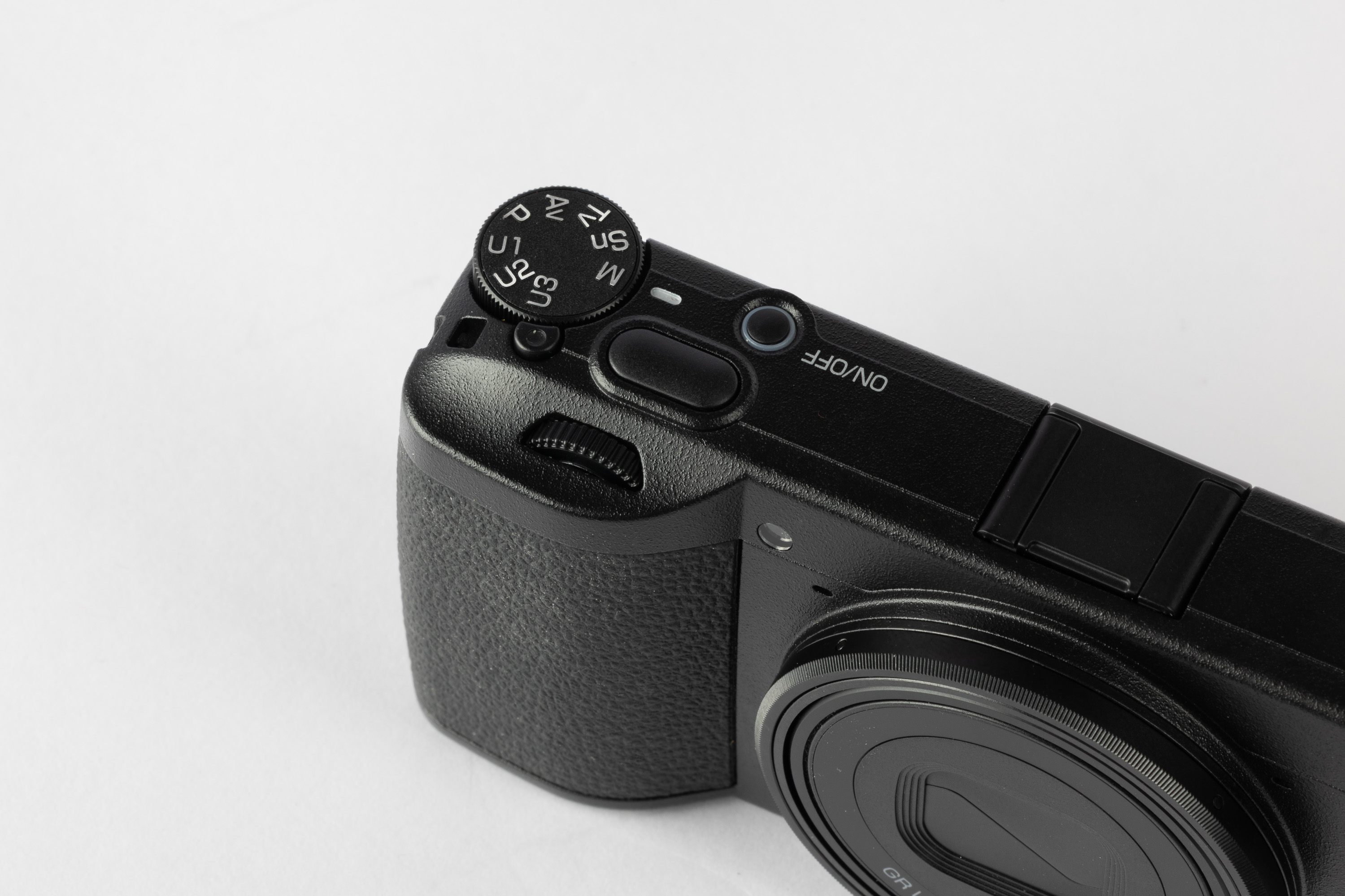 Vorderseite der Ricoh GR IV mit dem Ein-/Ausschalter und den Einstellrädern auf der Deckplatte