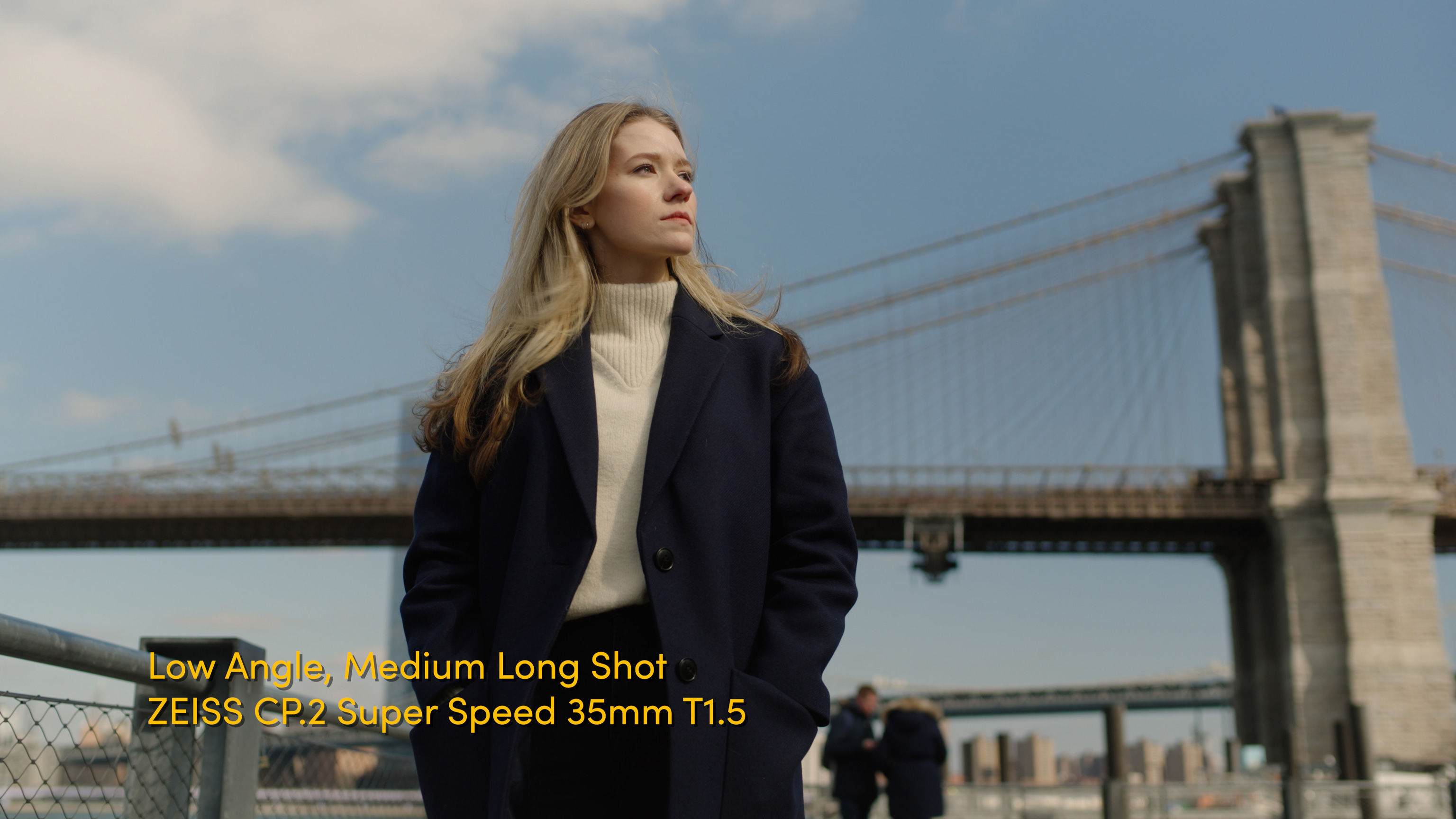 Example of a low angle medium long shot with woman in front of Brooklyn Bridge in New York City