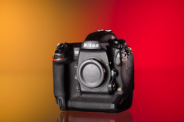 Cámara Nikon D5 de segunda mano sobre un fondo amarillo y rojo