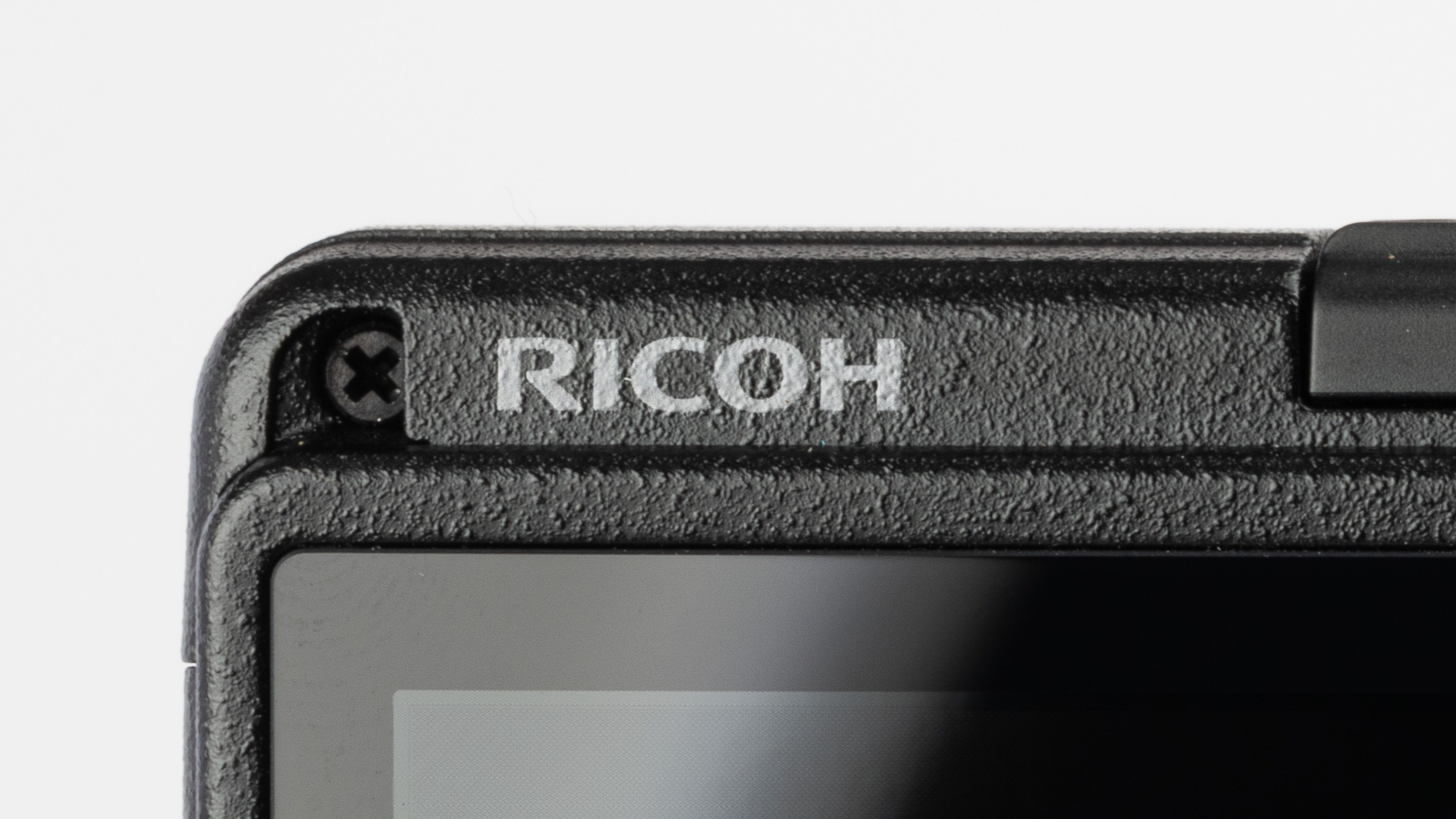 Extreme close-up of the Ricoh logo on a Ricoh GR camera