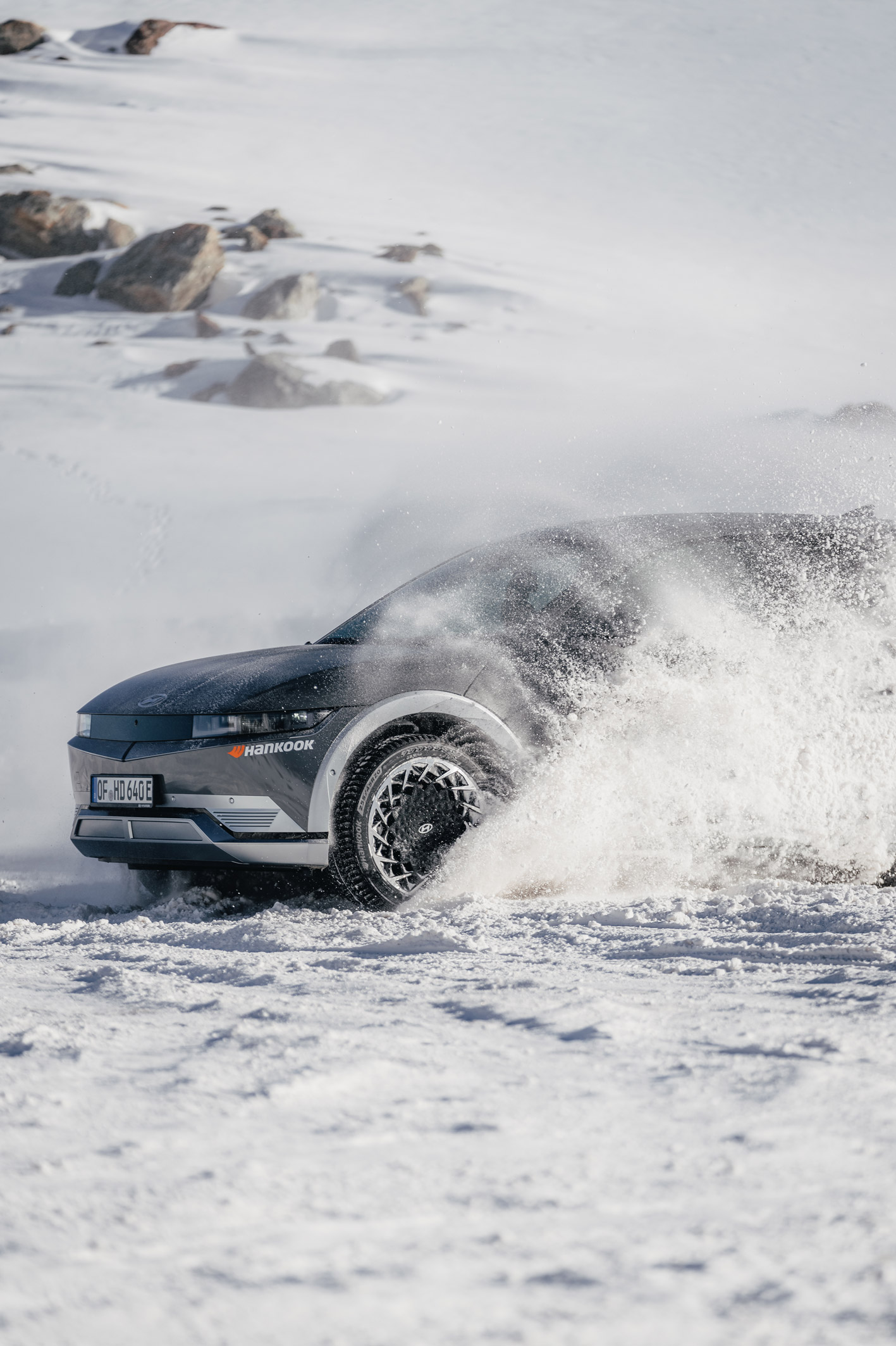 Grey Hyundai SUV drives through snow and ice on top of a glacier in Austria