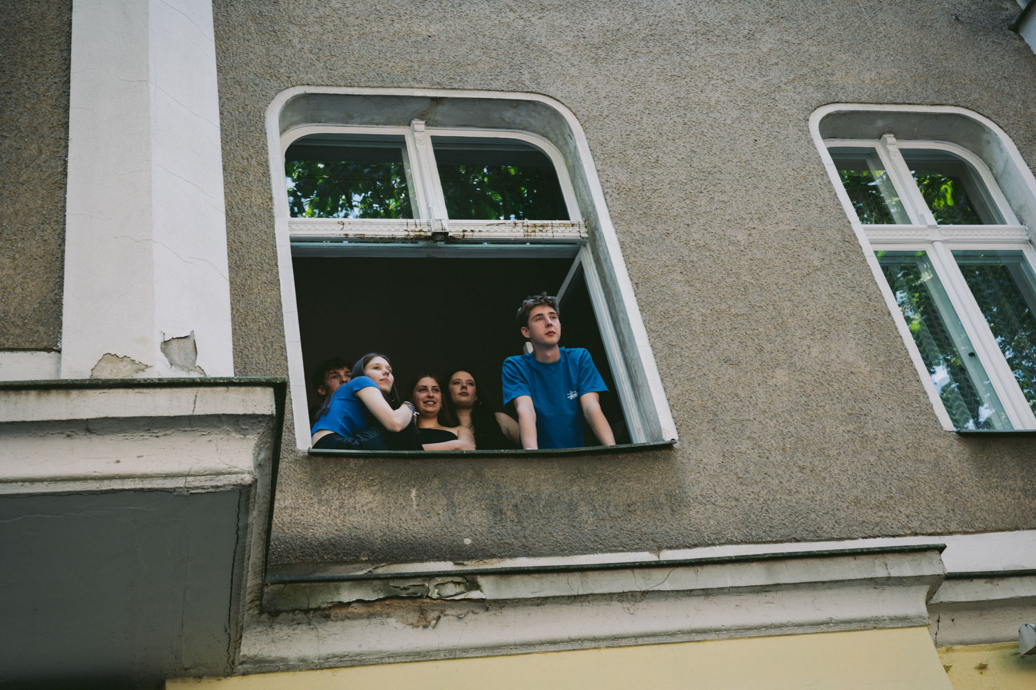 People looking out of a window, photographed from a frog's-eye view, shot by Stefanie Schmid Rincon with the Canon EOS R6