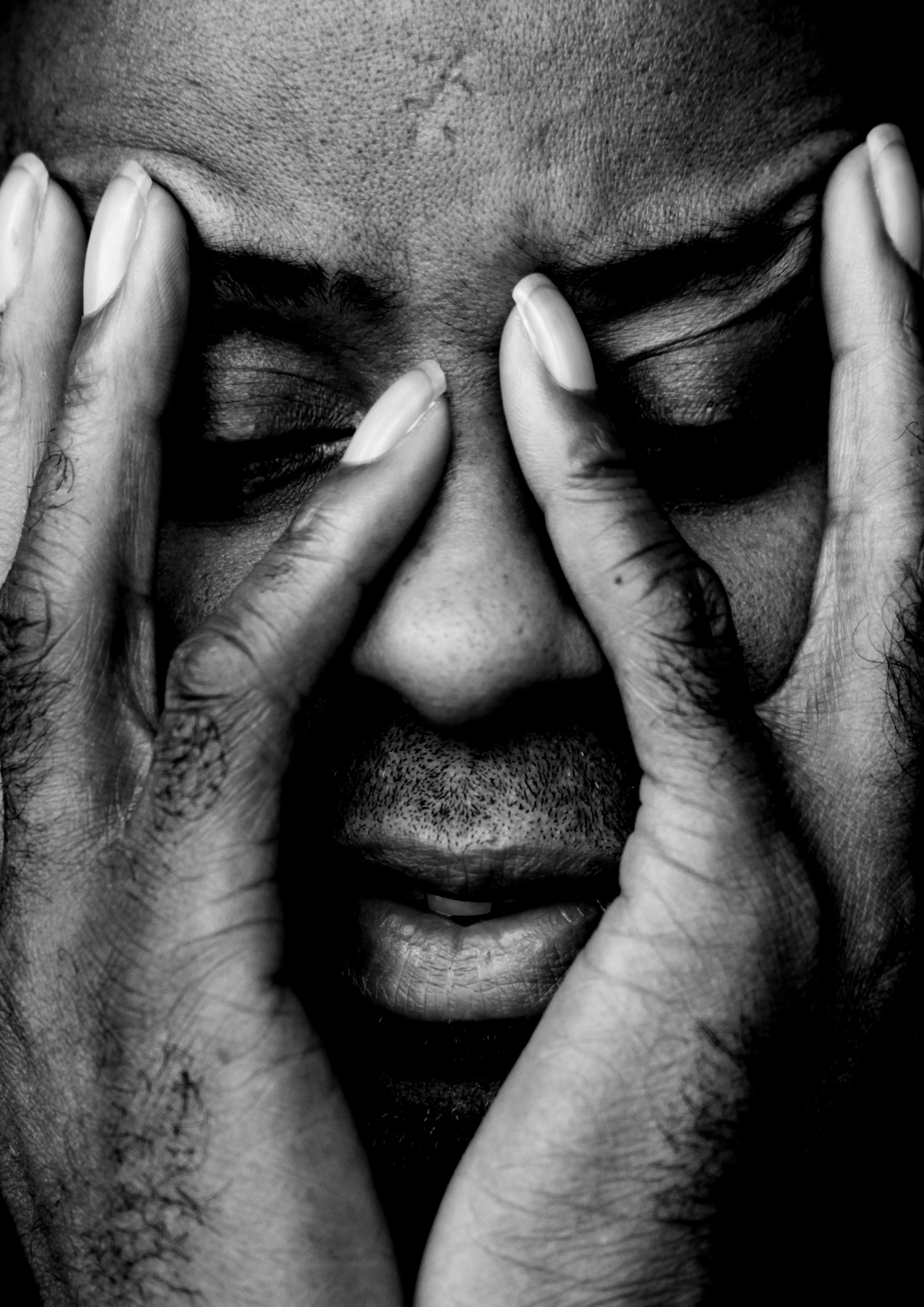 Gros plan du visage d'une personne tenant ses mains devant son visage. Photo prise par Marie Staggat avec un Canon EOS 5D Mark II.
