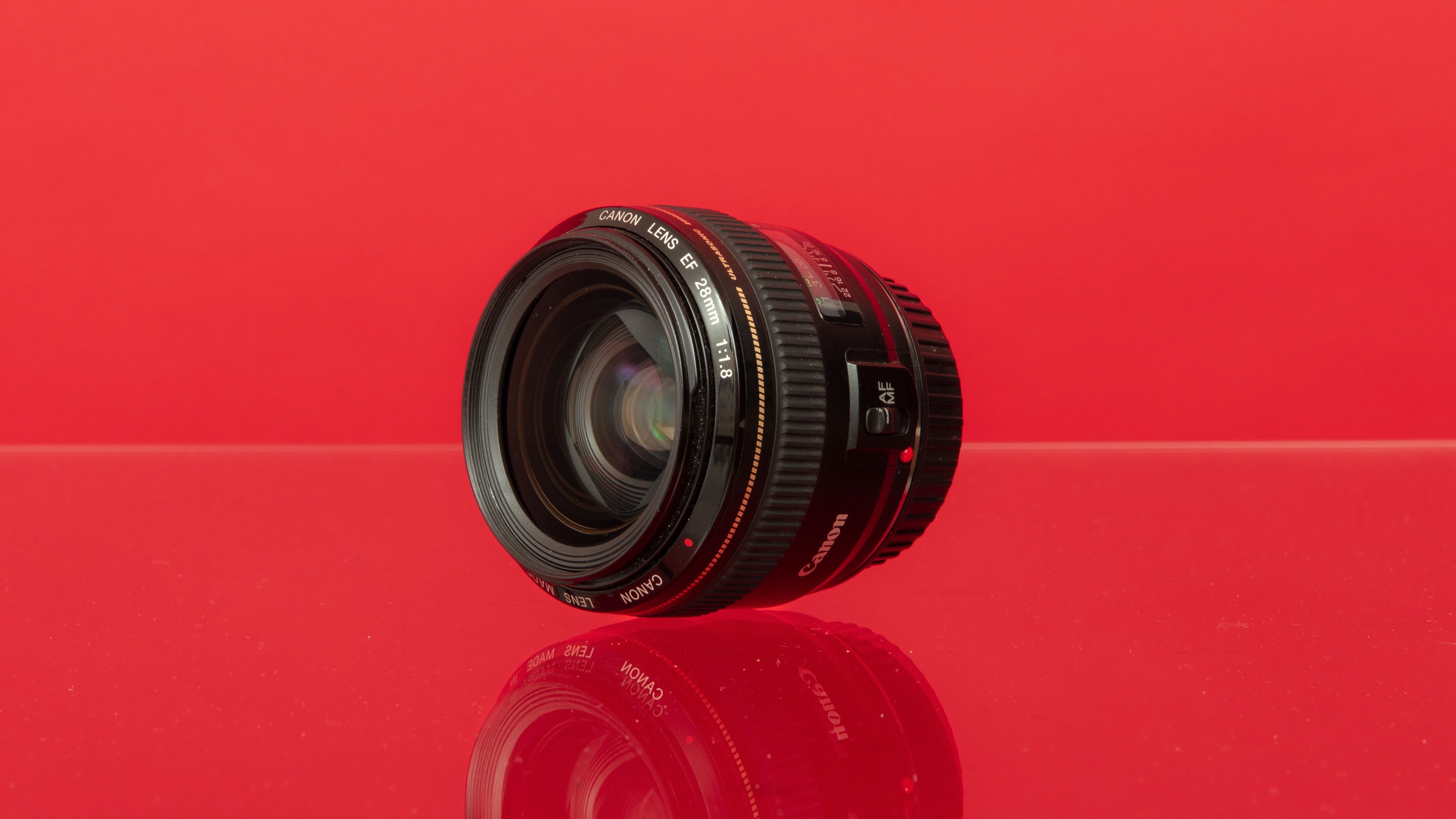 Used Canon EF 28mm f/1.8 USM from MPB on a red background