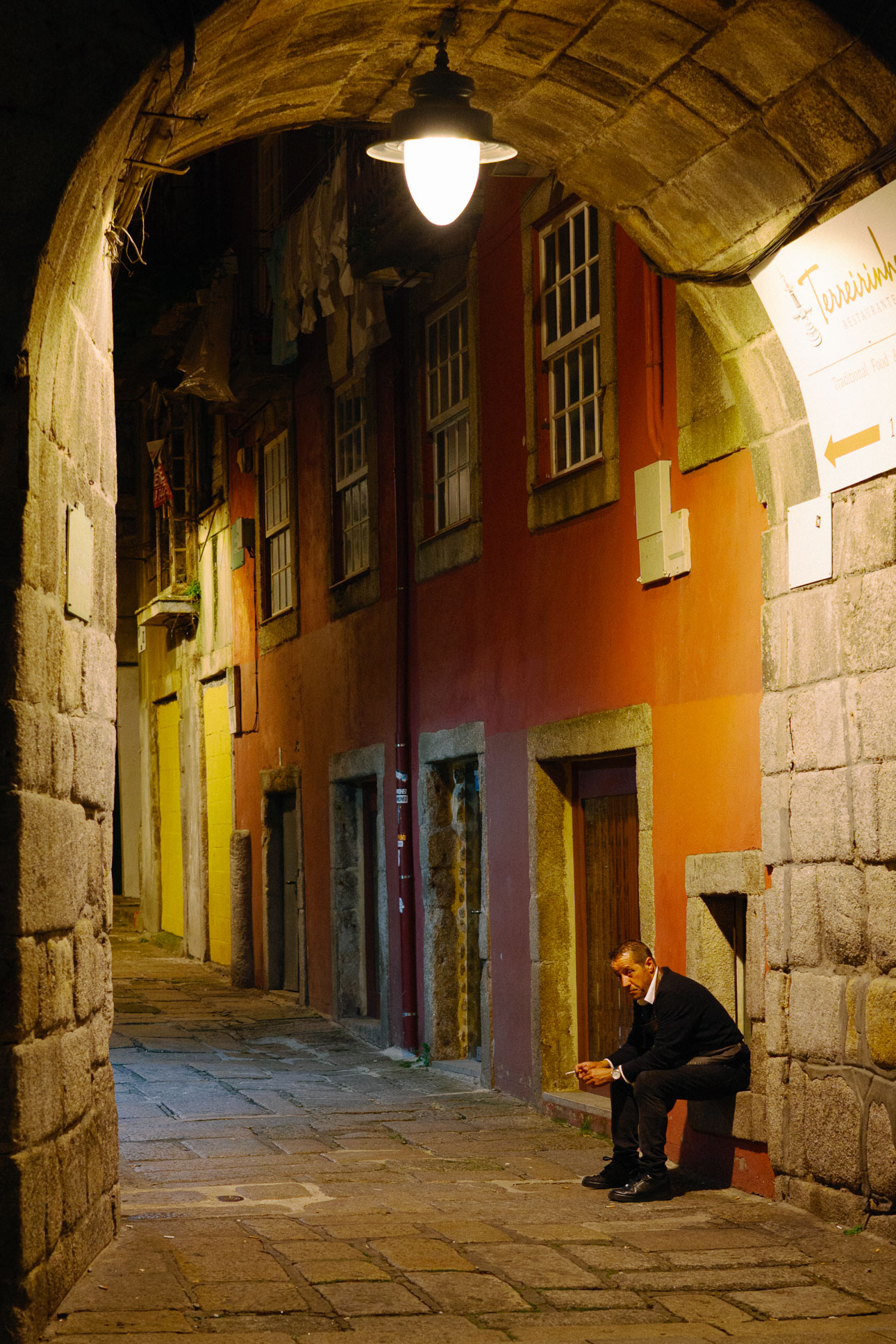 Person, die abends in einer Fasse in Porto sitzt und Pause macht. Aufgenommen von Connor Redmond mit der Sigma BF.