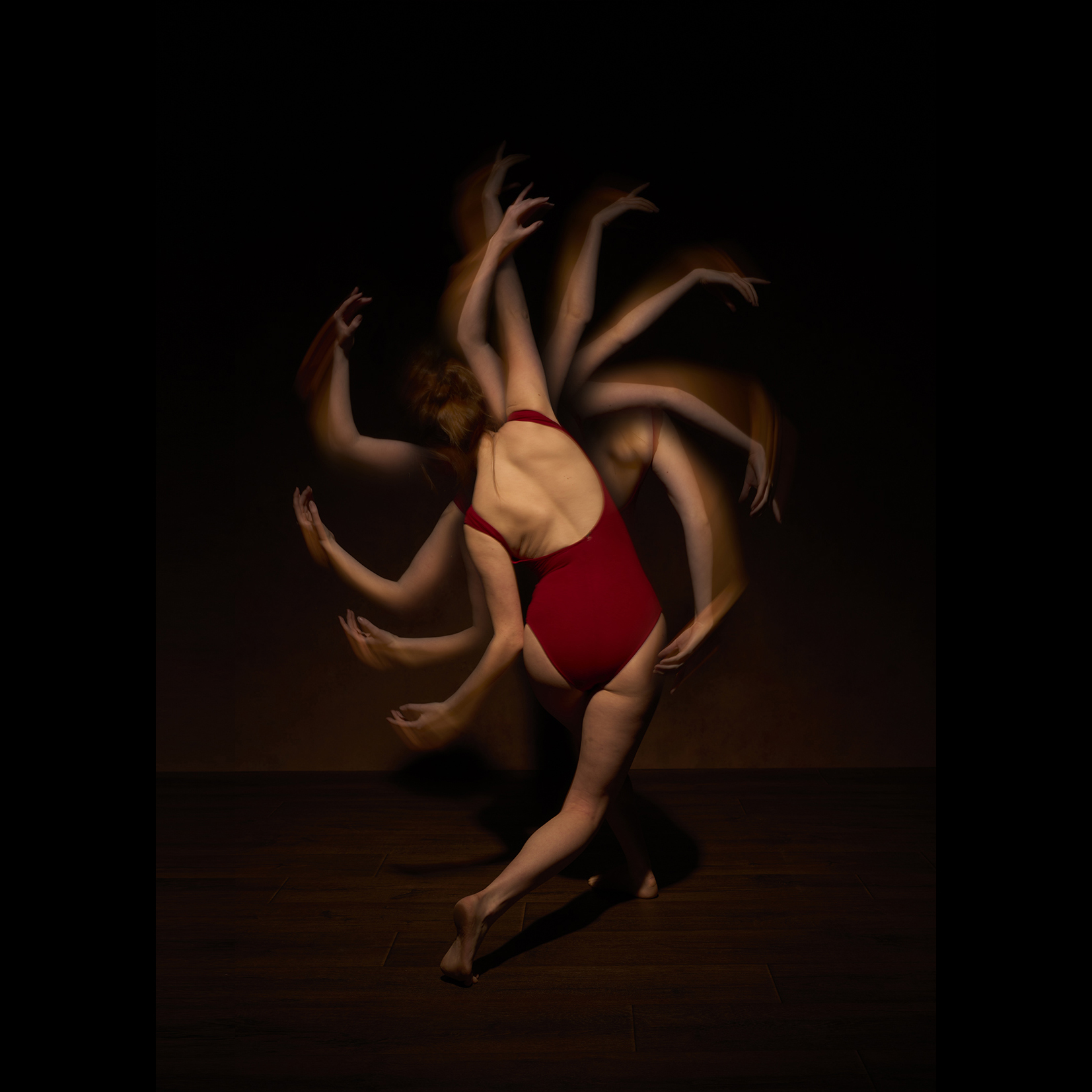 Dancer in red showing multiple arms through multiple exposures