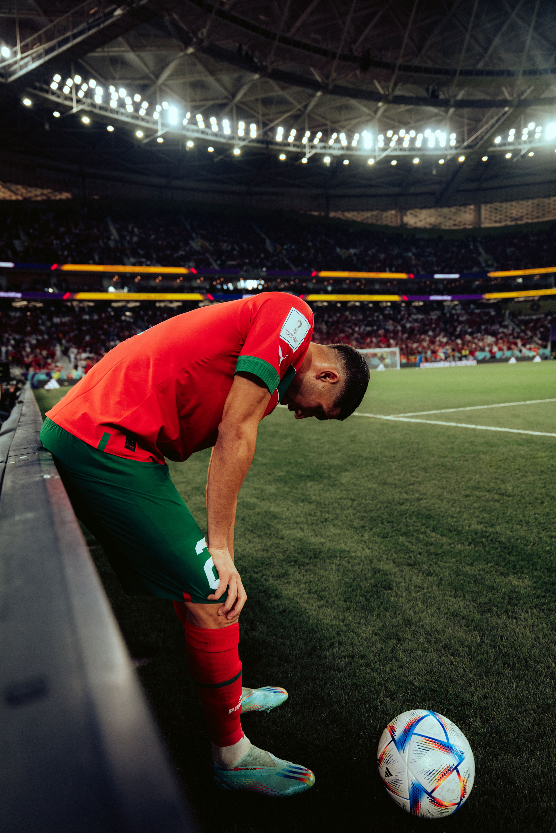 Portugal football player on the edge of the pitch leaning forward on their knees, shot by Lukas Mengeler

