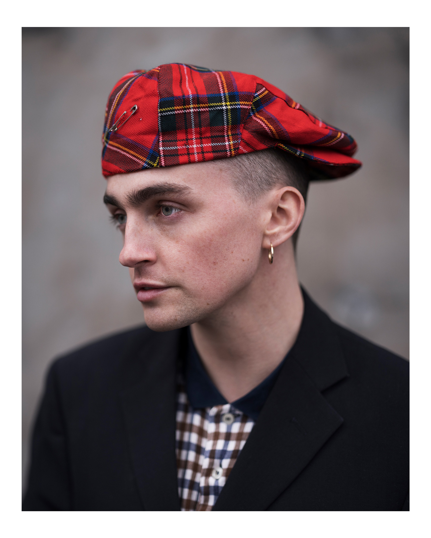 A close-up portrait of a model wearing a red tartan tam o' shanter hat, photo by Simon Murphy with the Fujifilm GFX 100