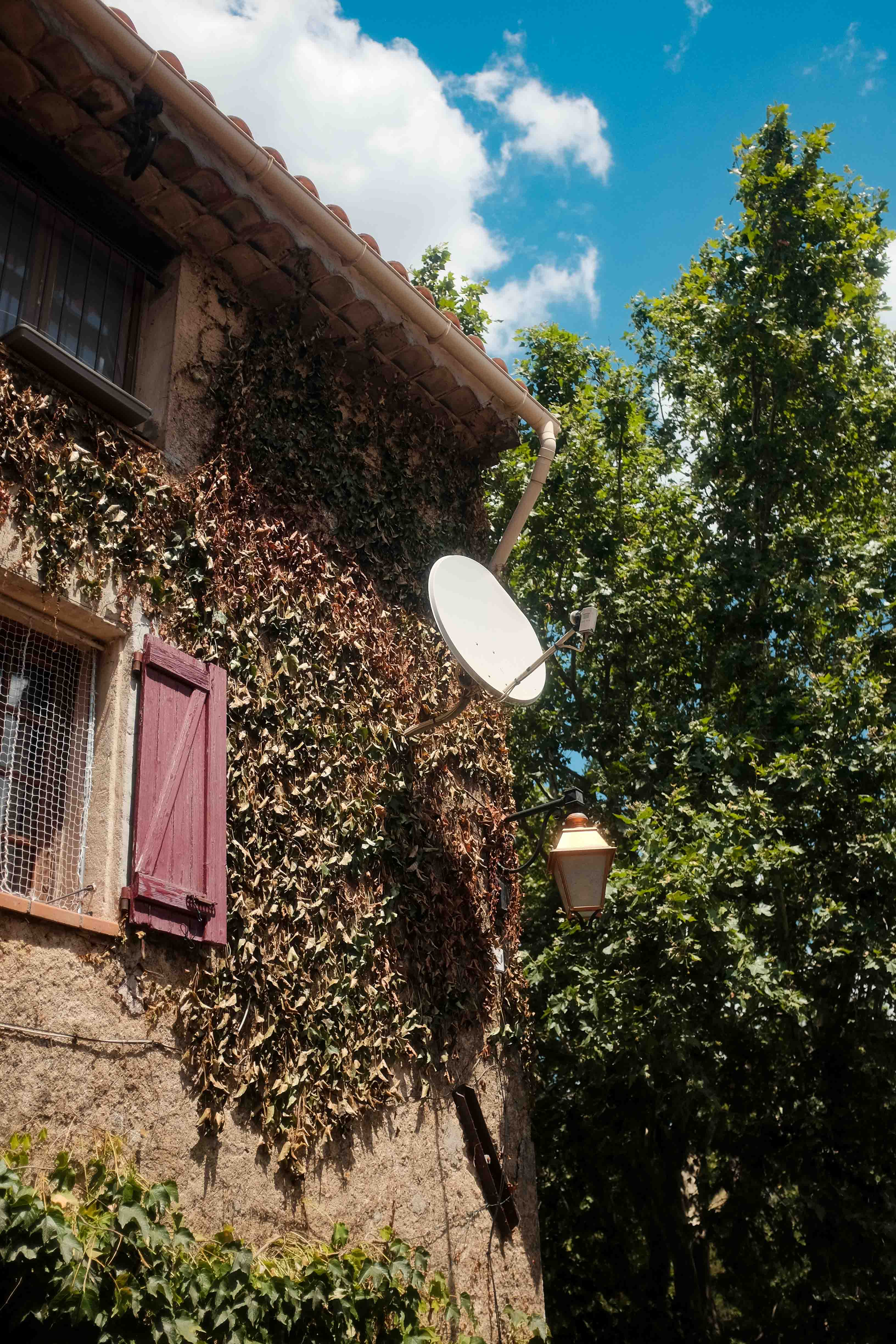 A satellite dish attached to a building in cute southern french village. Taken on the Fujifilm X100T by Connor Redmond.