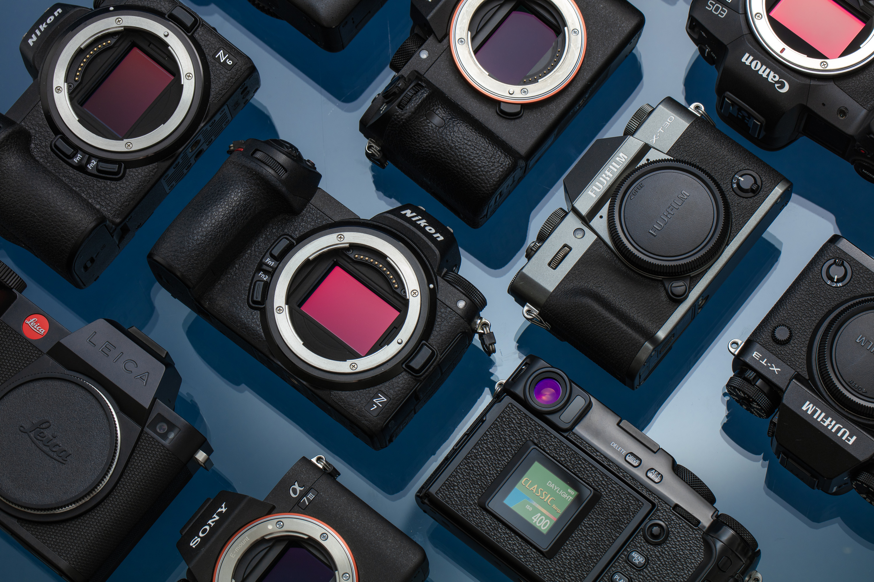 Disposición de varias cámaras mirrorless sobre un fondo azul