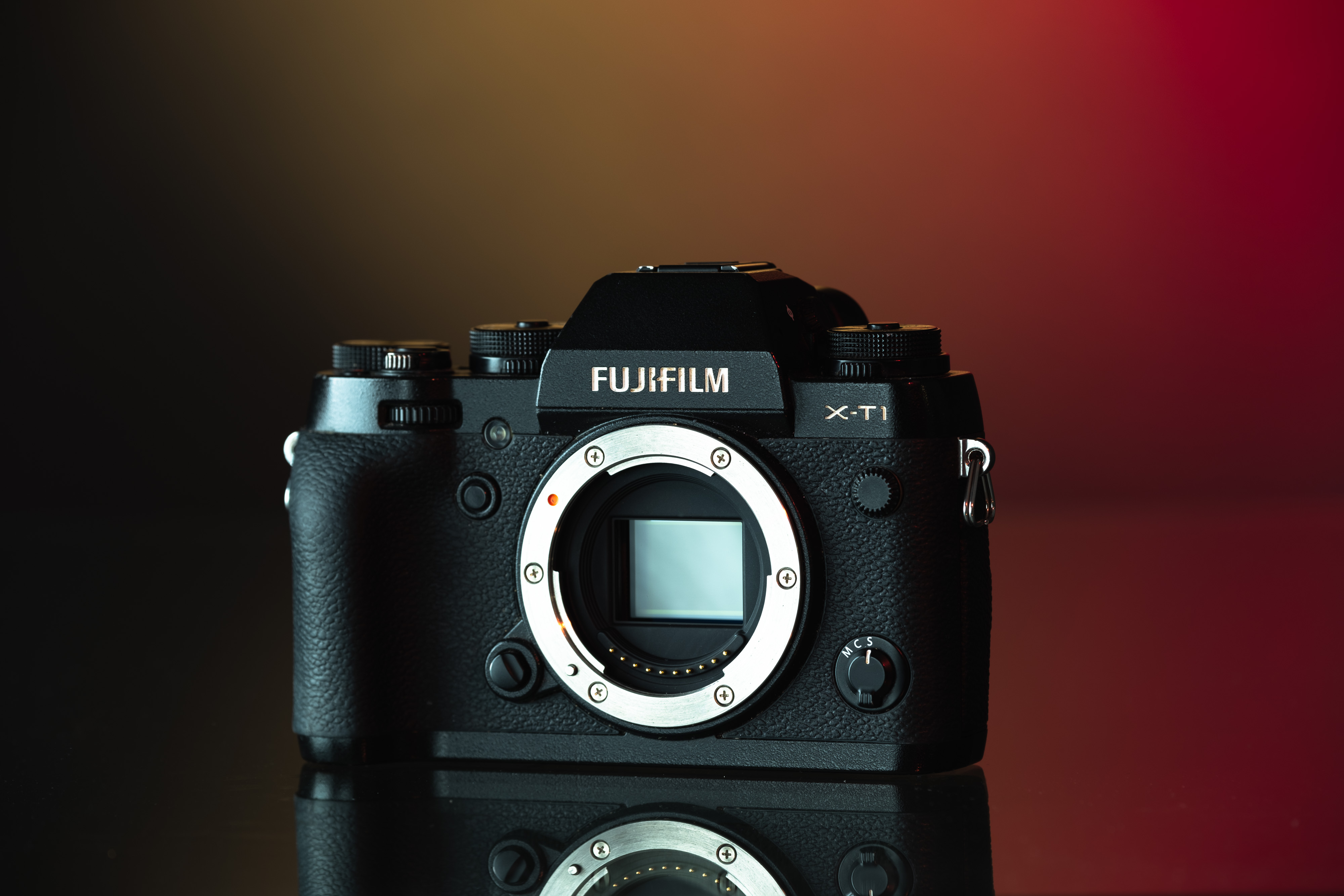 A full-spectrum converted Fujifilm X-T1 on a red, orange and black background