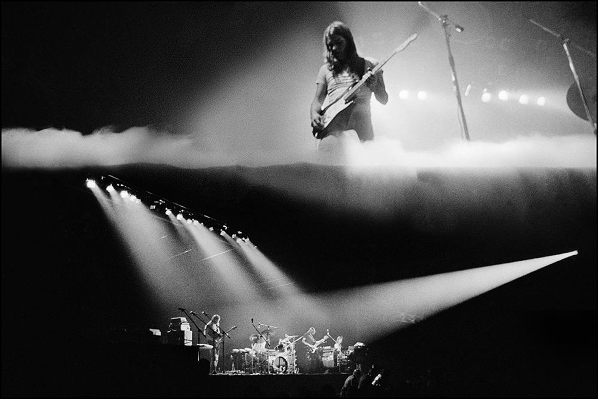 Zwei Schwarz-Weiß-Bilder von Pink Floyd auf der Bühne, zusammengefügt, von Jill Furmanovsky