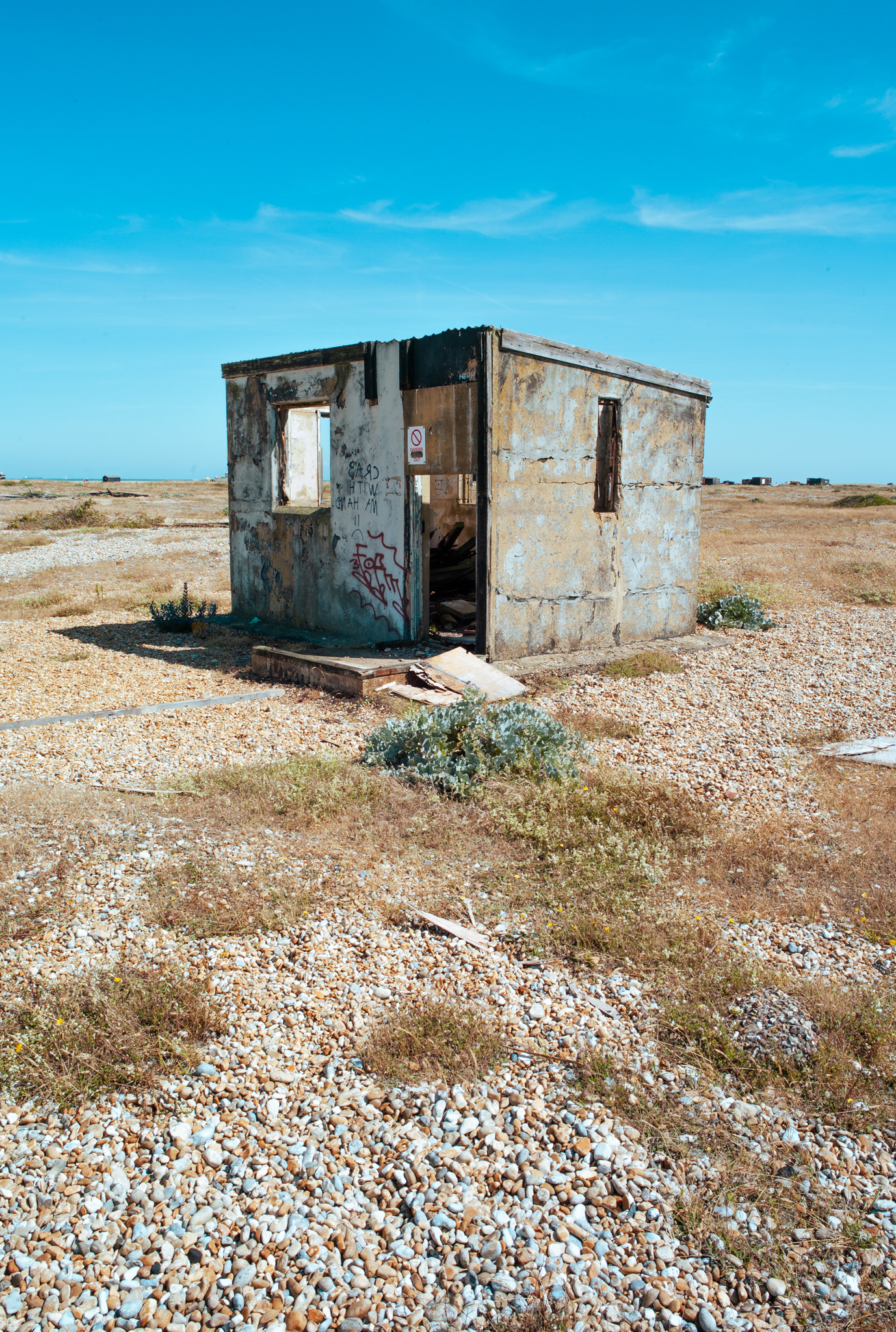 Ein kleines, bröckelndes Betonbauwerk am Strand von Dungeness 


