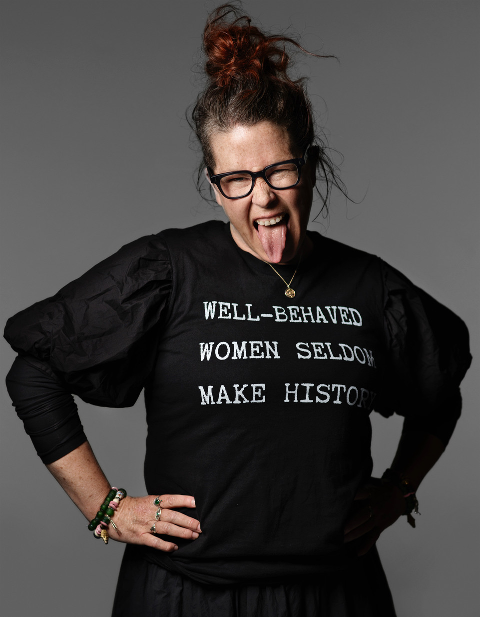 Ein Porträt von Karni Arieli, die ein schwarzes T-Shirt mit weißer Aufschrift trägt, auf dem steht: “Well-behaved women seldom make history”.
