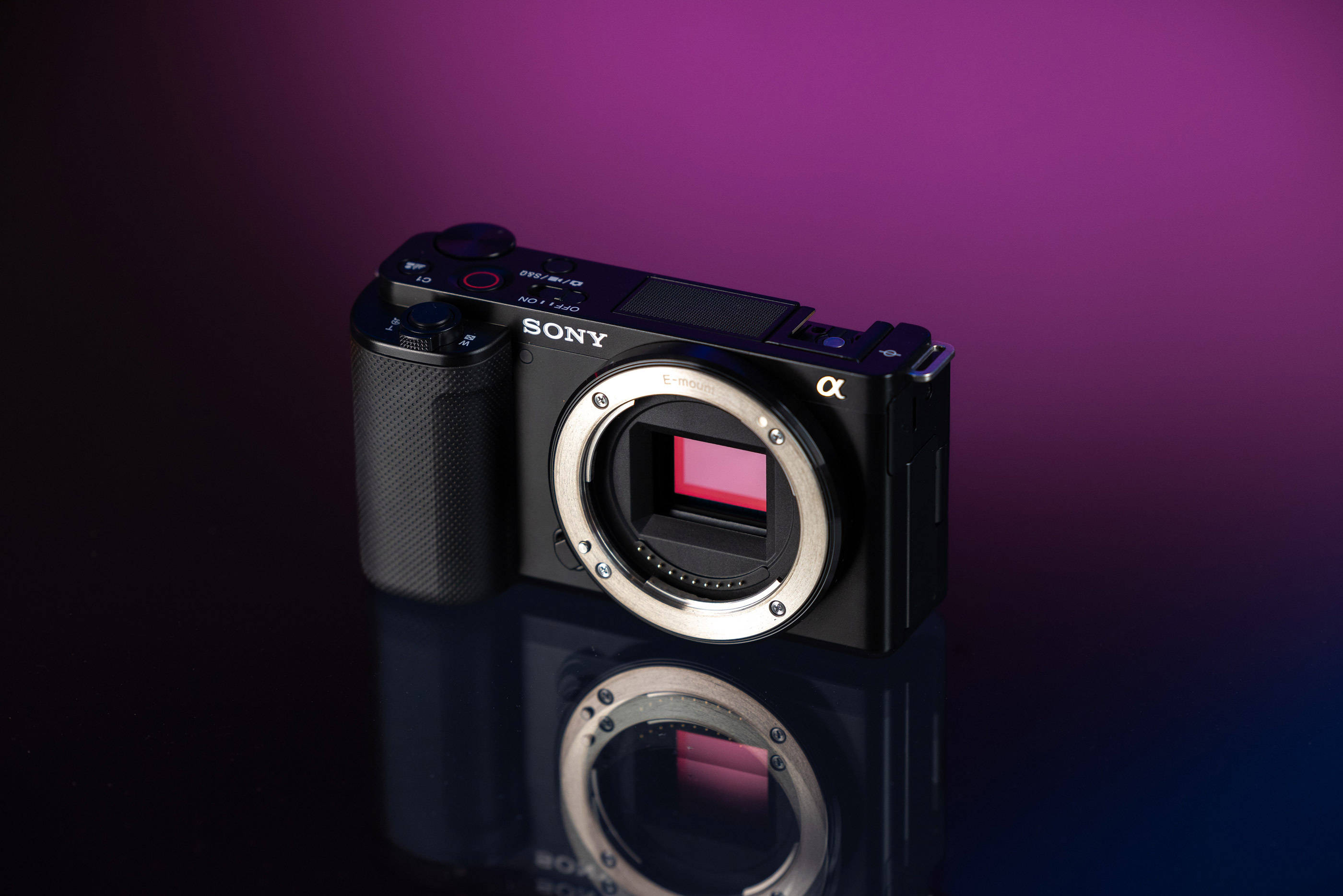 Sony ZV-E10 vor einem lila-schwarzen Hintergrund.