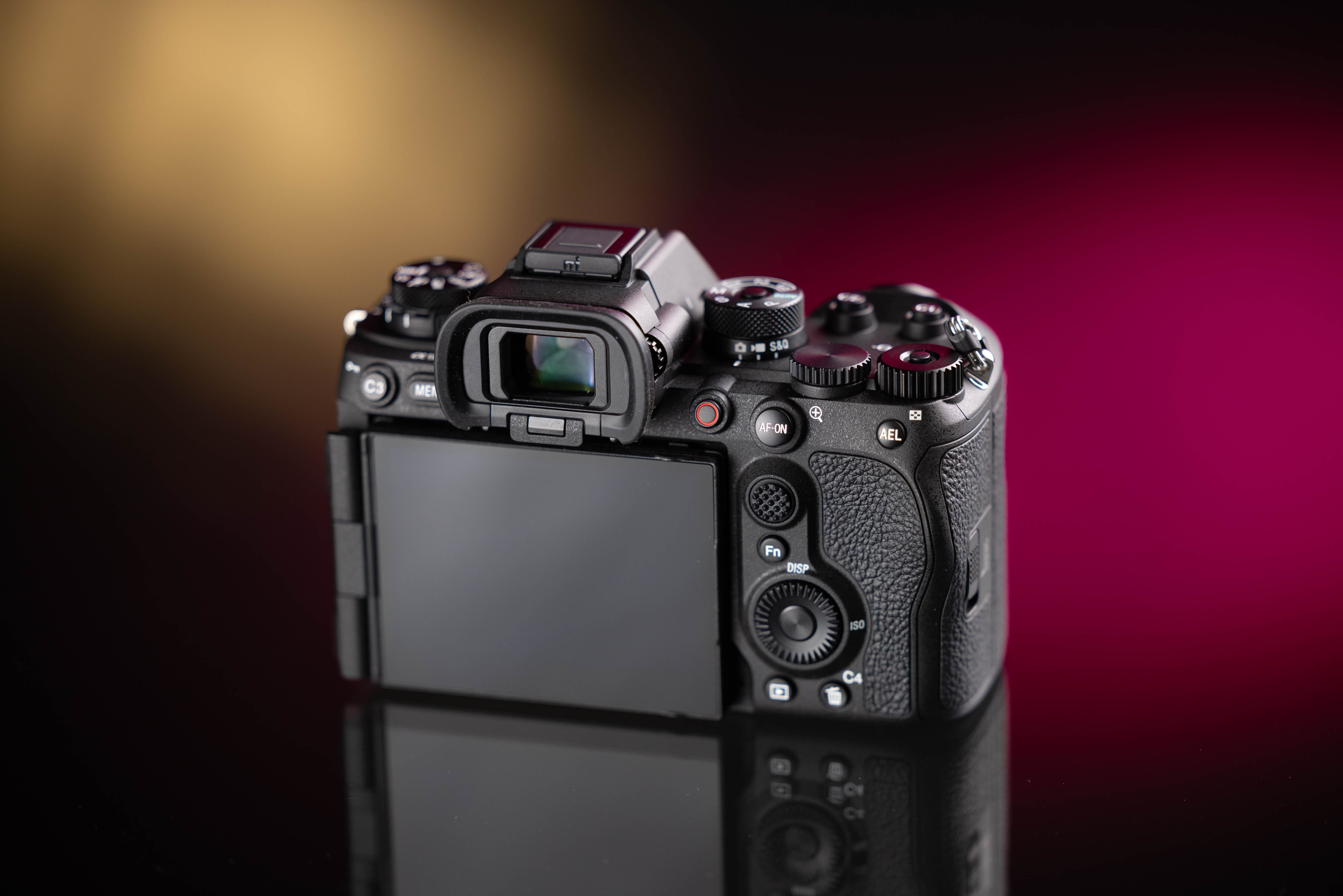 Achterkant van de Sony A9 III op een gele en roze achtergrond