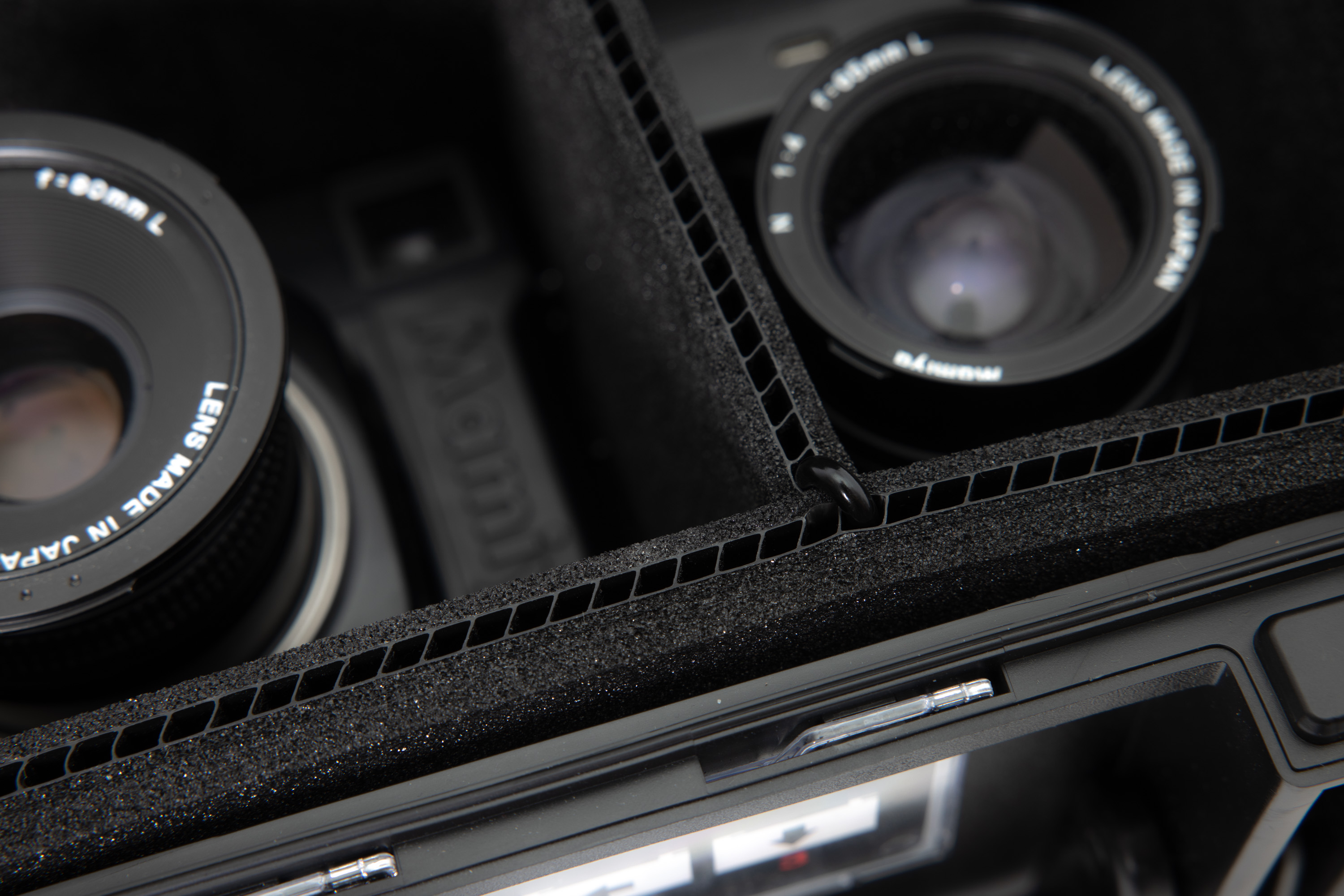 A close-up photo of the Peli 1535 Air Case, showing the TrekPak inserts holding two cameras and lenses