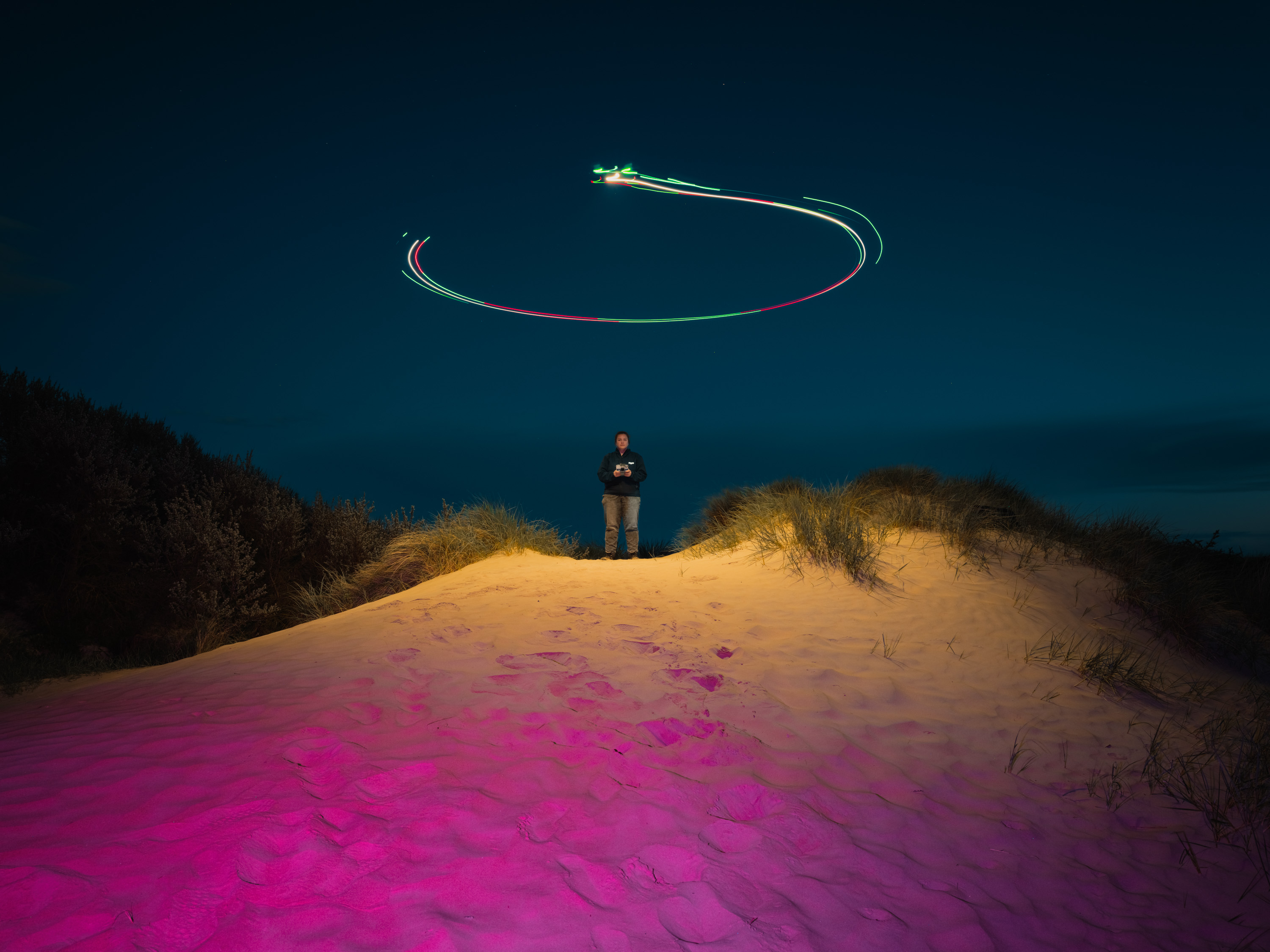 Een lange belichting op een zandduin met een drone met een lamp aan die een haloachtig licht boven het onderwerp creëert. Door Ian Howorth.