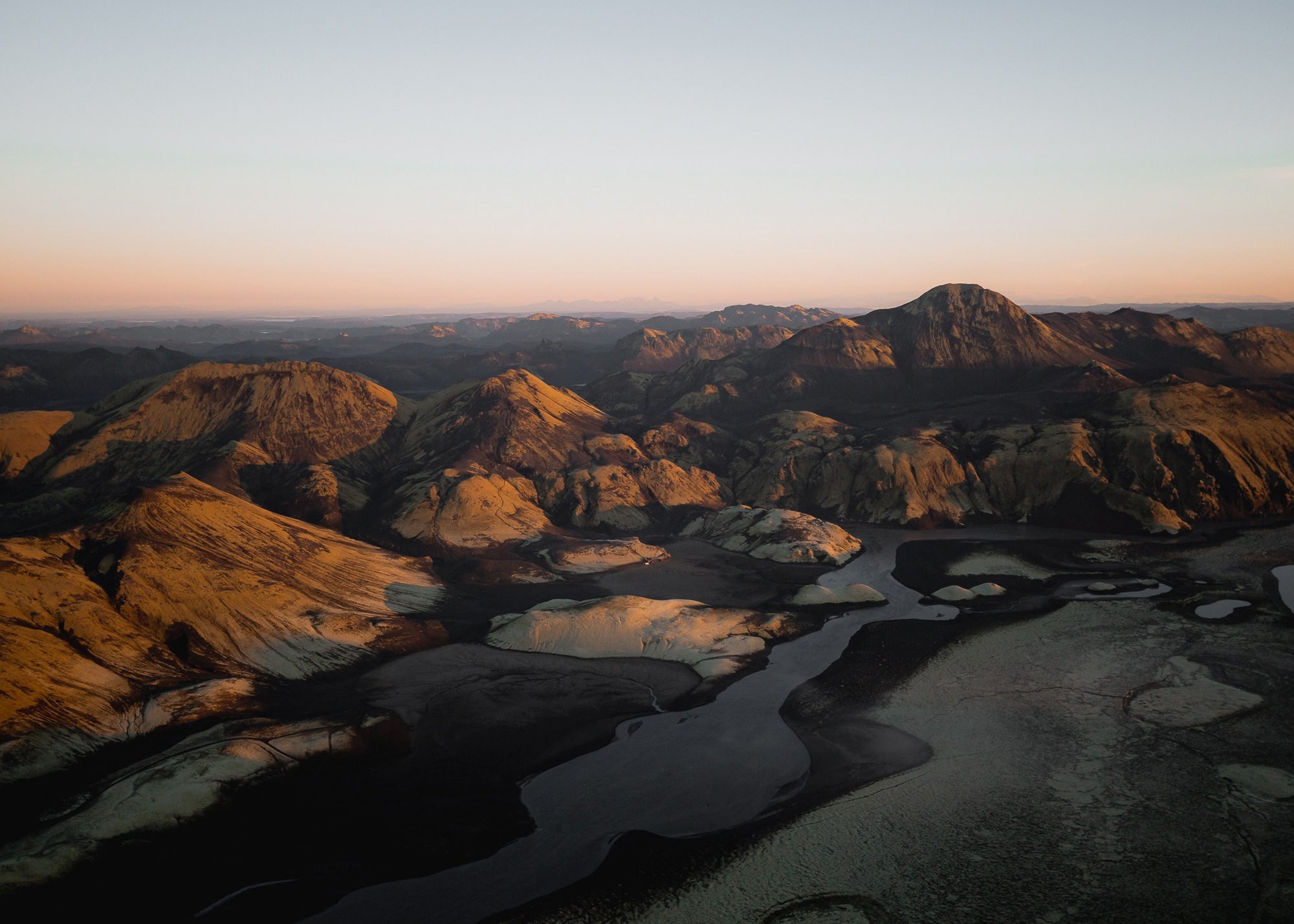Ein Drohnen-Landschaftsbild von einer Reihe dunkelgrauer Berge in Island mit einem graublauen Himmel darüber, aufgenommen von Paul Watson mit einer DJI Mavic 2 Pro