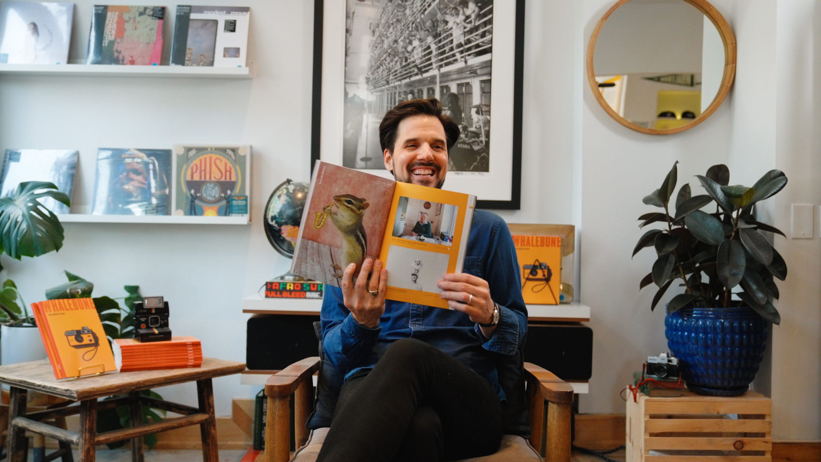 AWA Founder Wally Koval laughing while showing a photo from the Accidentally Wes Anderson book.