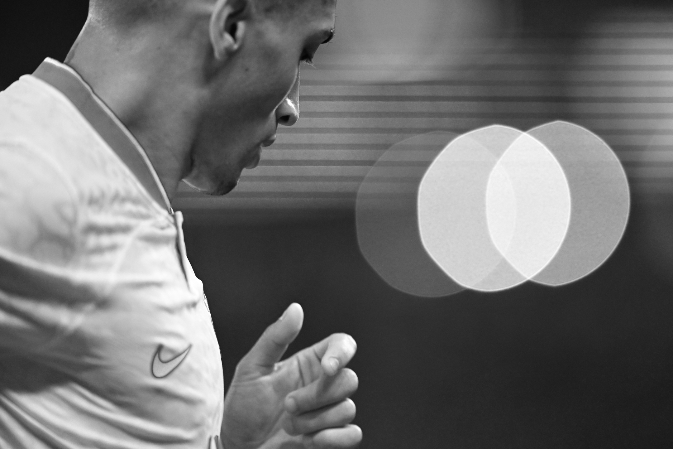 Ein Schwarz-Weiß-Foto des brasilianischen Spielers Richarlison vor Bokeh-Lichtern während des 1:0-Sieges seiner Mannschaft gegen die Schweiz bei der Fußball-Weltmeisterschaft 2022, aufgenommen von Ryu Voelkel mit einer Nikon Z9.