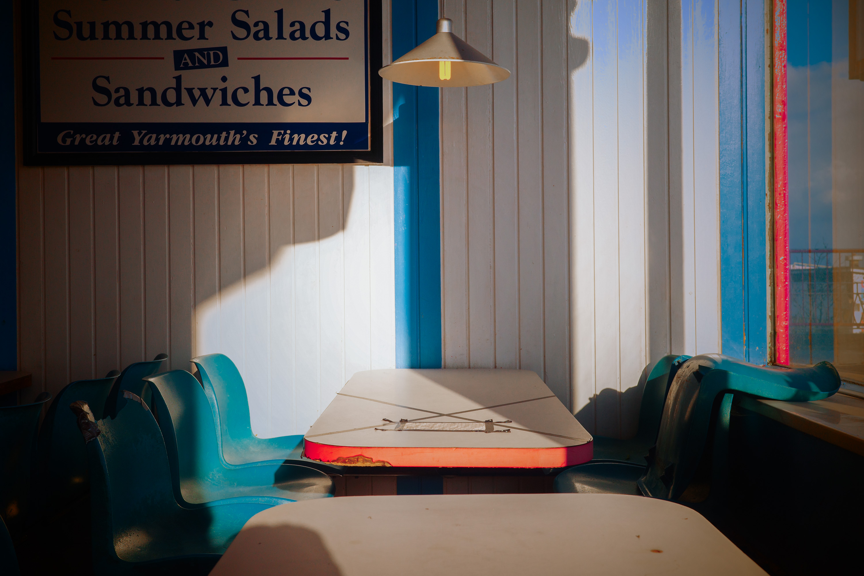 Ein Café in Great Yarmouth, Norfolk, mit einem Schild mit der Aufschrift "Summer Salads and Sandwiches" von Ian Howorth.
