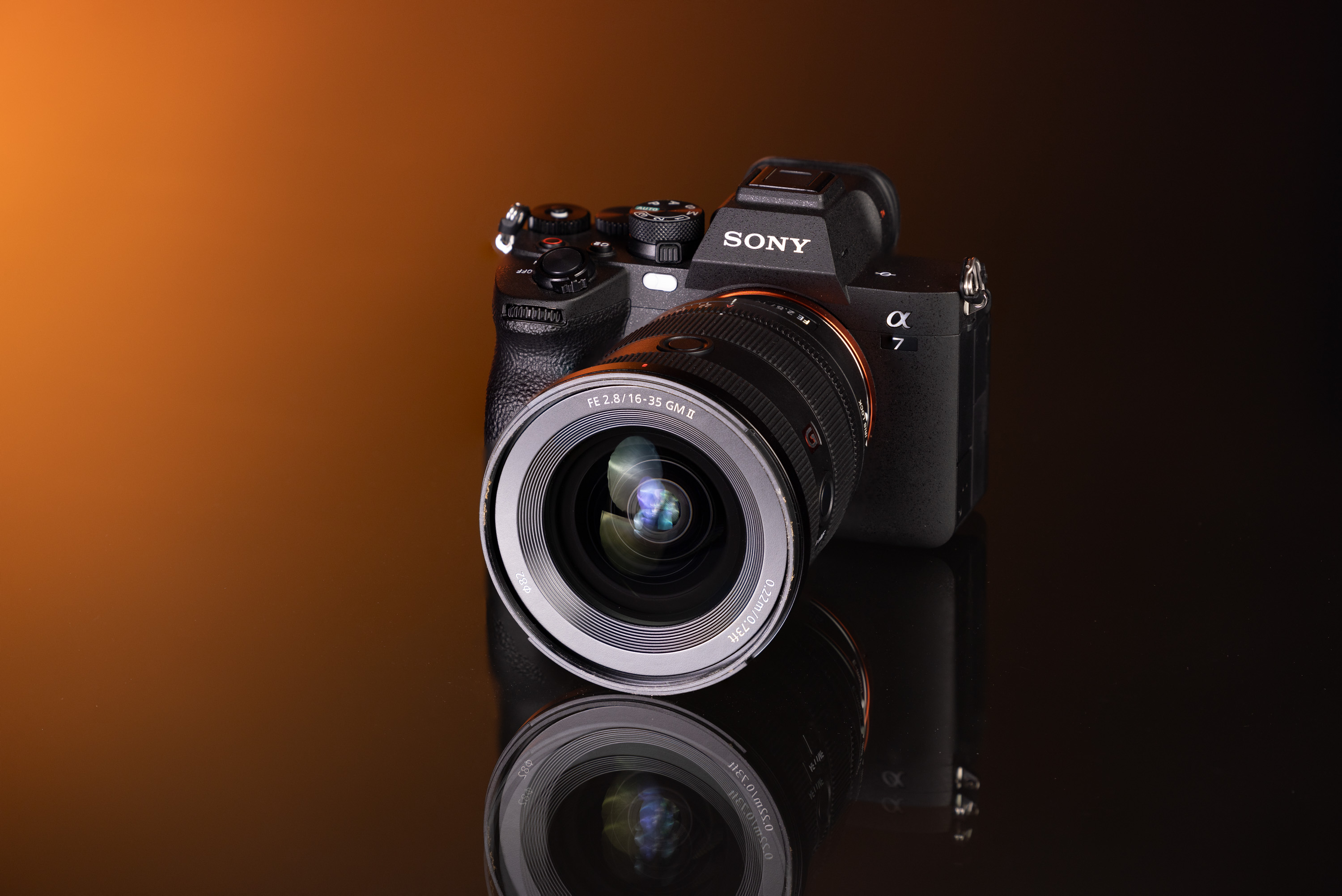 Tweedehands Sony A7 IV en Sony FE 16-35mm f/2.8 GM II lens op een oranje en zwarte achtergrond