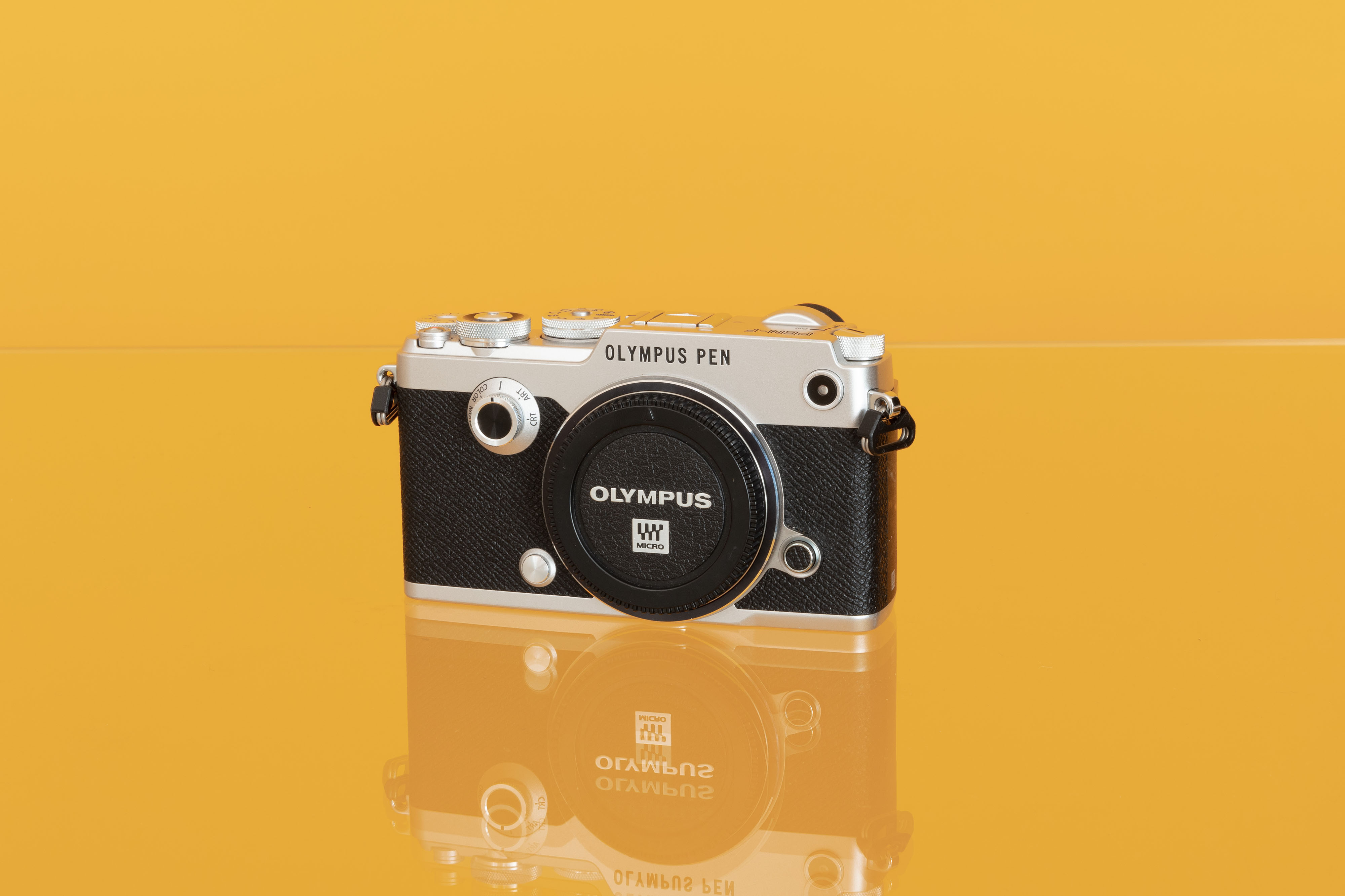 An Olympus PEN F shot against a yellow background