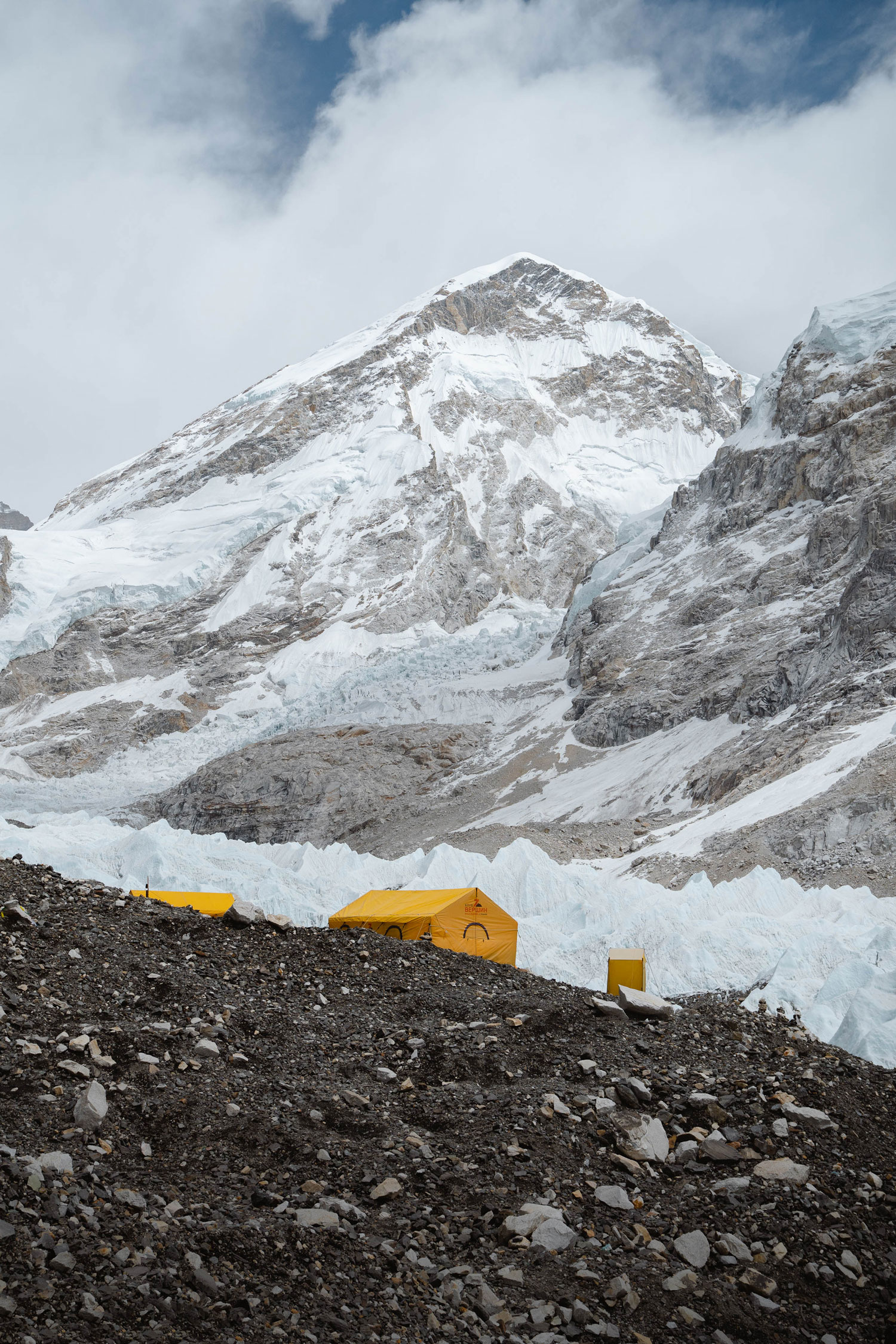 Two yellow tents on a rocky mountain side, with snow covered mountains in the background, shot by Jack Anstey with the Sony A7 IV and Sony FE 24-70mm f/2.8 GM