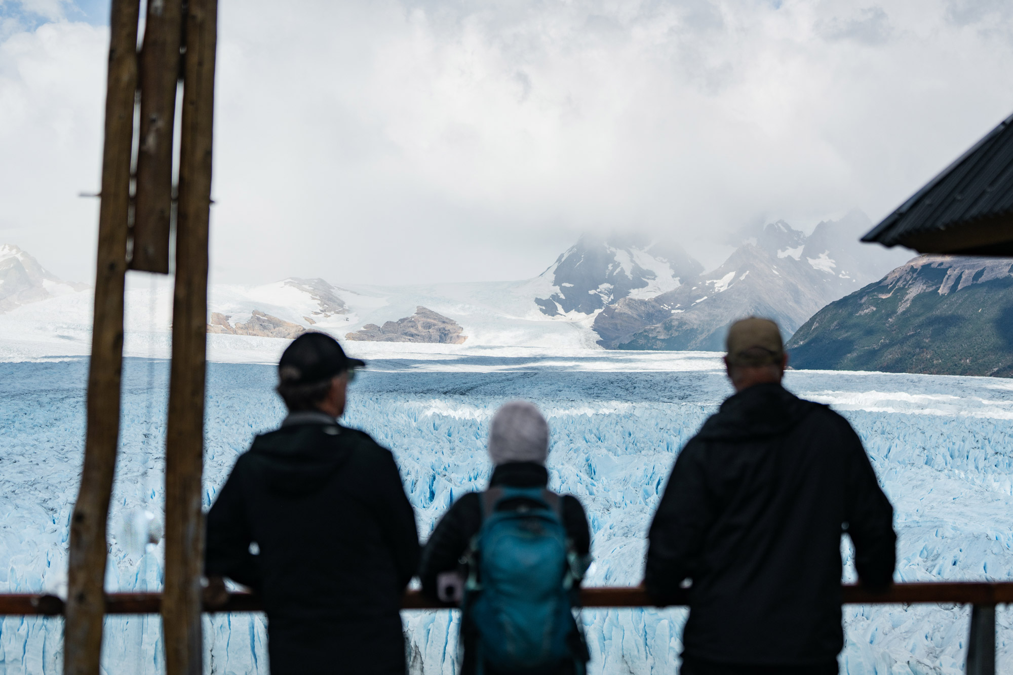 Three people photographed from behind looking at a glacier landscape, photographed by Marvin Kuhr with the Sony A7 IV.