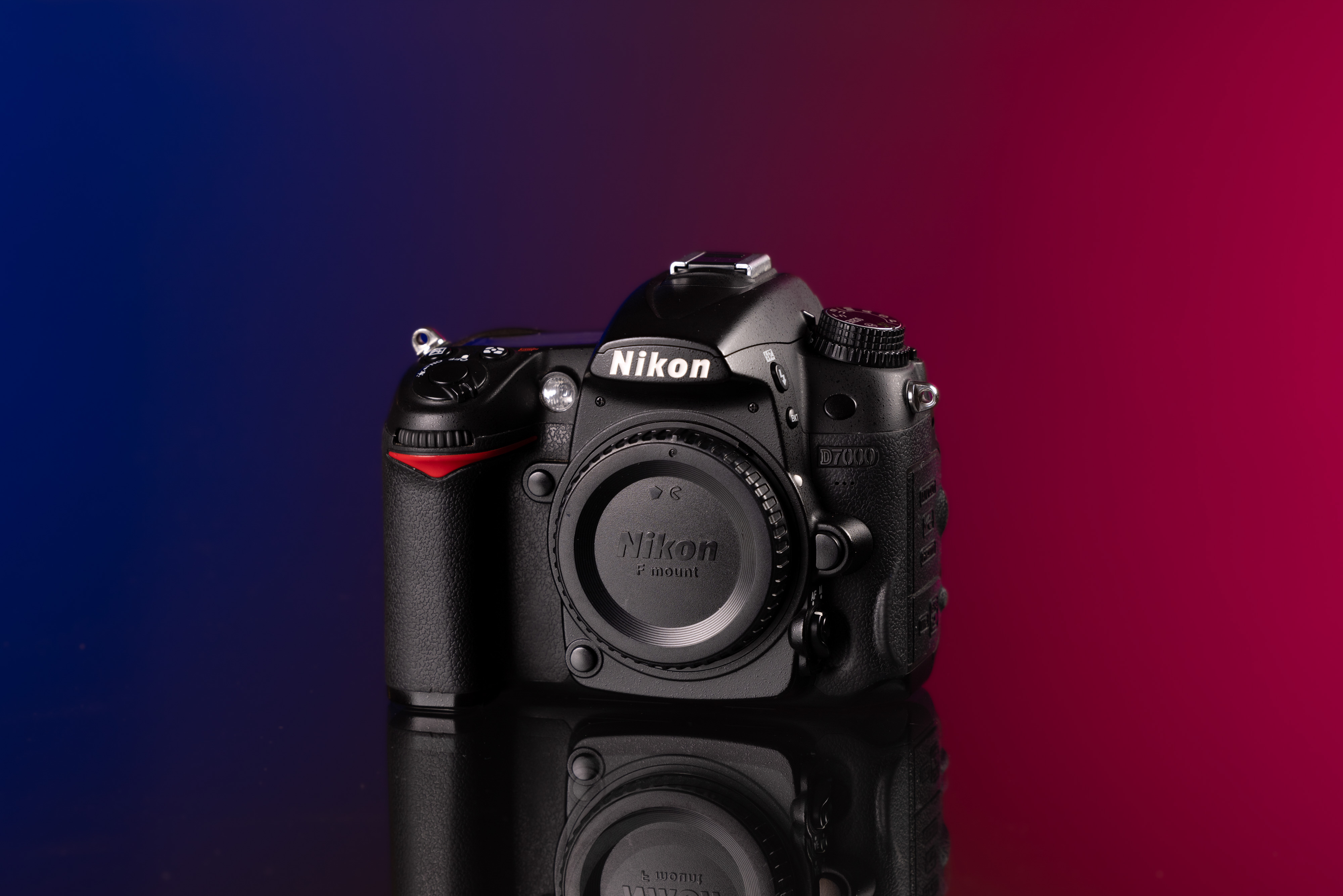 Gebrauchte Nikon D7000 vor einem blau-roten Hintergrund