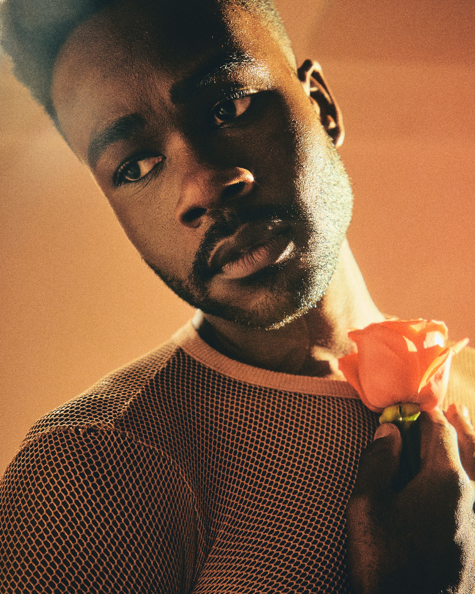 Portrait of model wearing white t-shirt and holding a flower