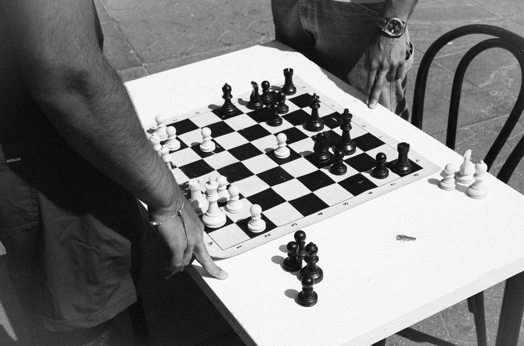 Une photo en noir et blanc d'une partie d'échecs jouée dans le parc, photo par Ian Howorth