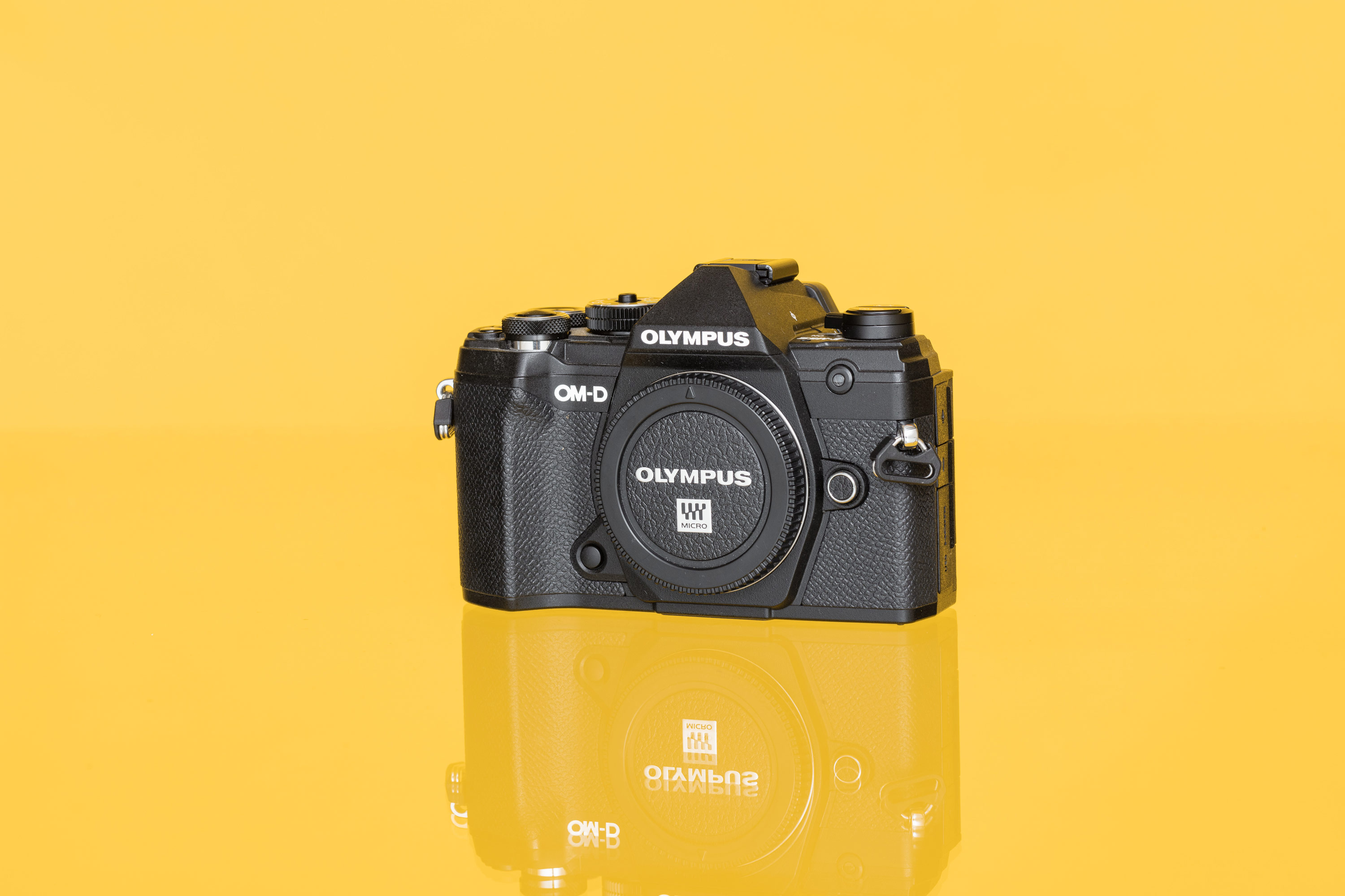 An Olympus OM-D E-M5 III shot against a yellow background
