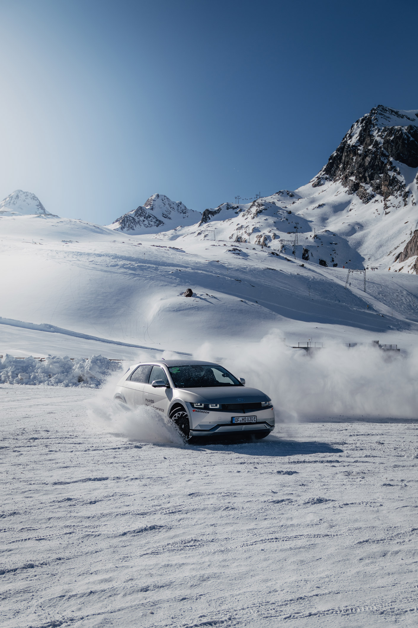 Vehicle drifting across a snowy mountaintop on top of a glacier in Austria with sky in the background