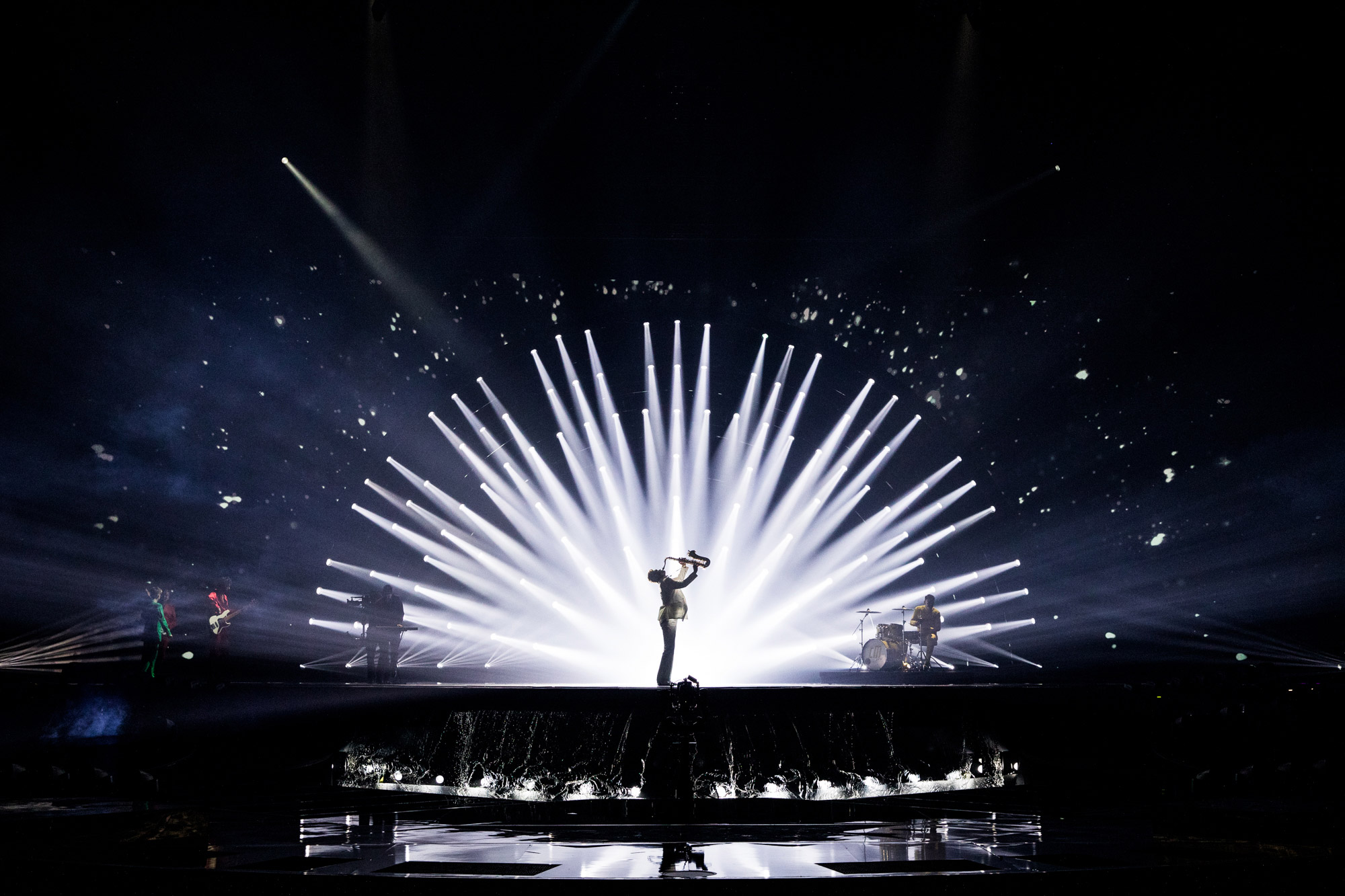Man on stage at Eurovision playing an instrument in the lights
