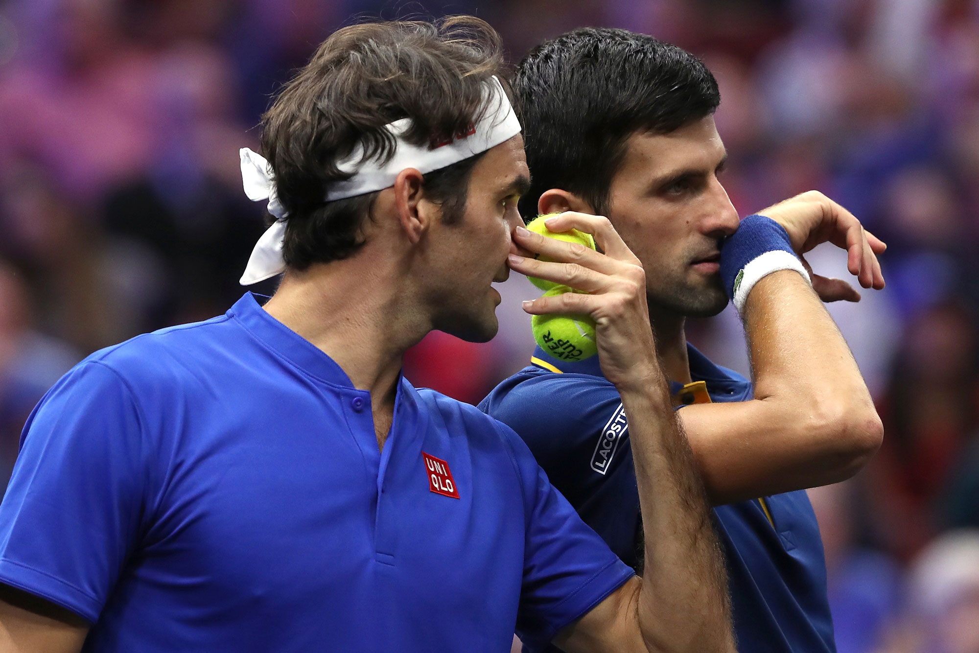 Team Europe Roger Federer of Switzerland and Team Europe Novak Djokovic of Serbia confer between points while playing Team World Jack Sock of the United States and Team World Kevin Anderson of South Africa during their Men's Doubles match of the 2018 Laver Cup in Chicago, Illinois.
