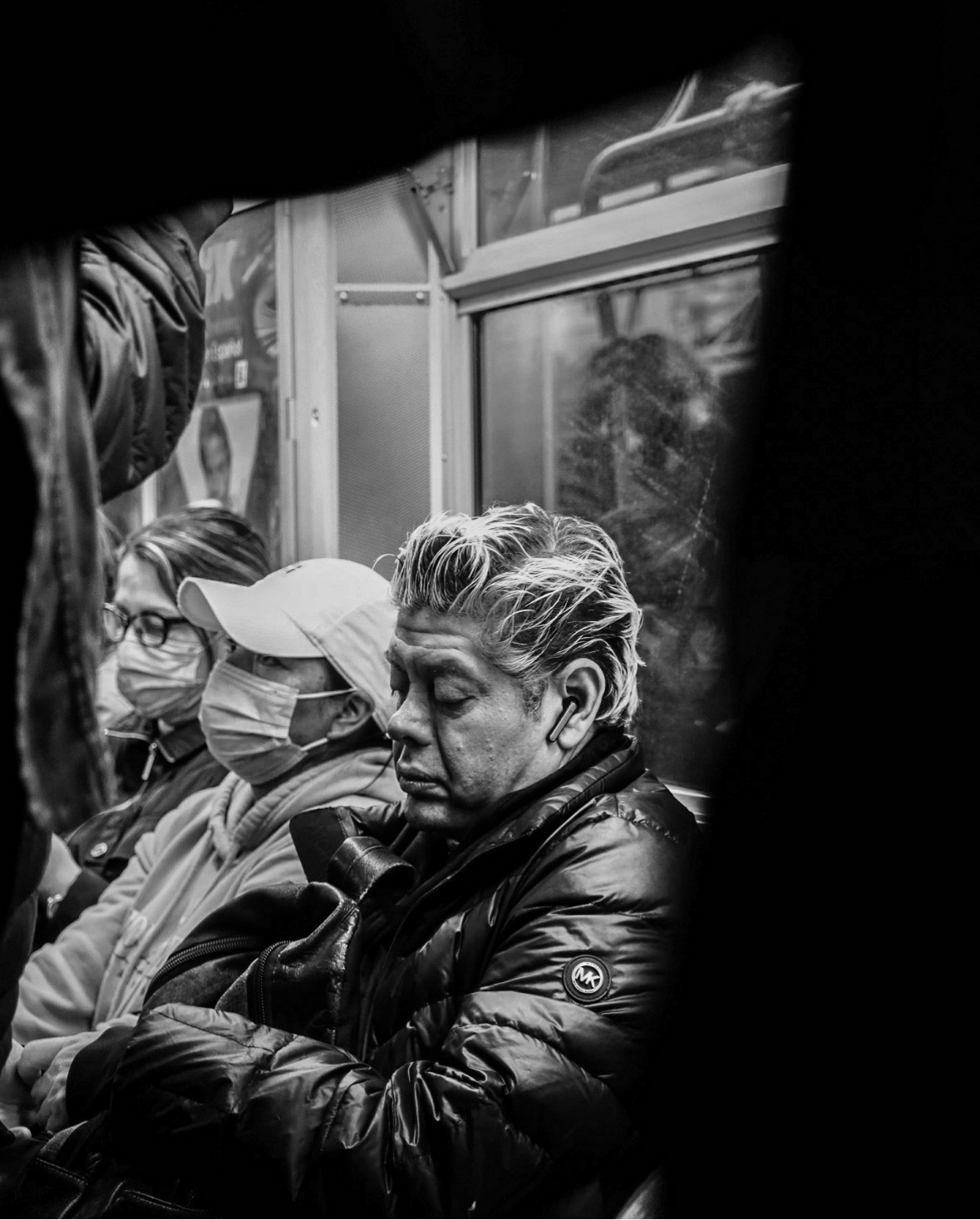 A black-and-white photo of a passenger on the NYC subway looking down on the floor, shot by Stephanye Floyd with a Fujifilm X-H2S