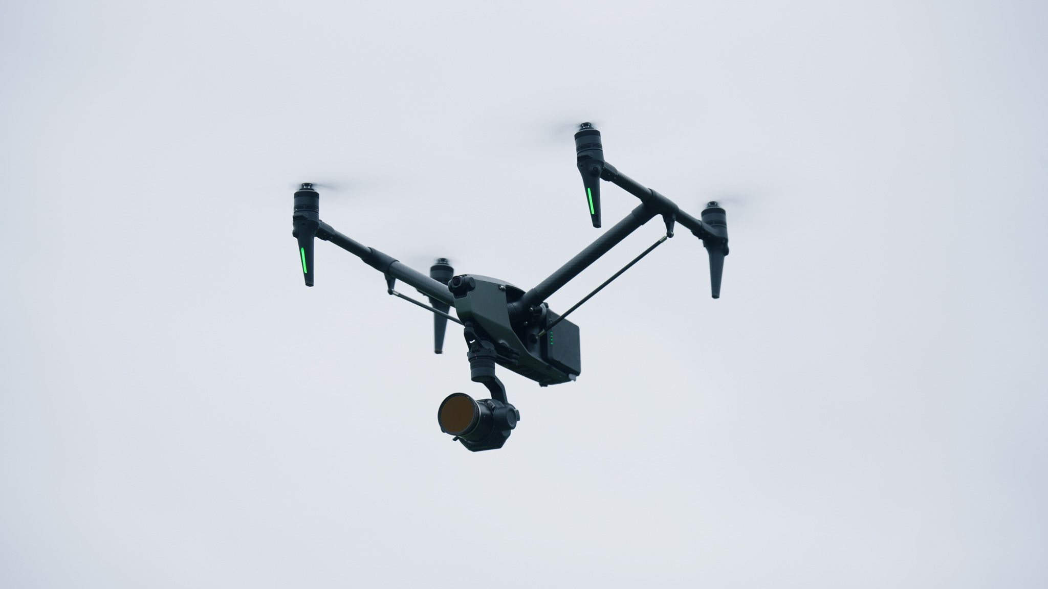 De DJI Inspire 3, een professionele drone uitgerust met een geavanceerde camera en gimbal, vastgelegd in actie tegen een grijze lucht. Ideaal voor luchtfotografie en professionele videoproducties.