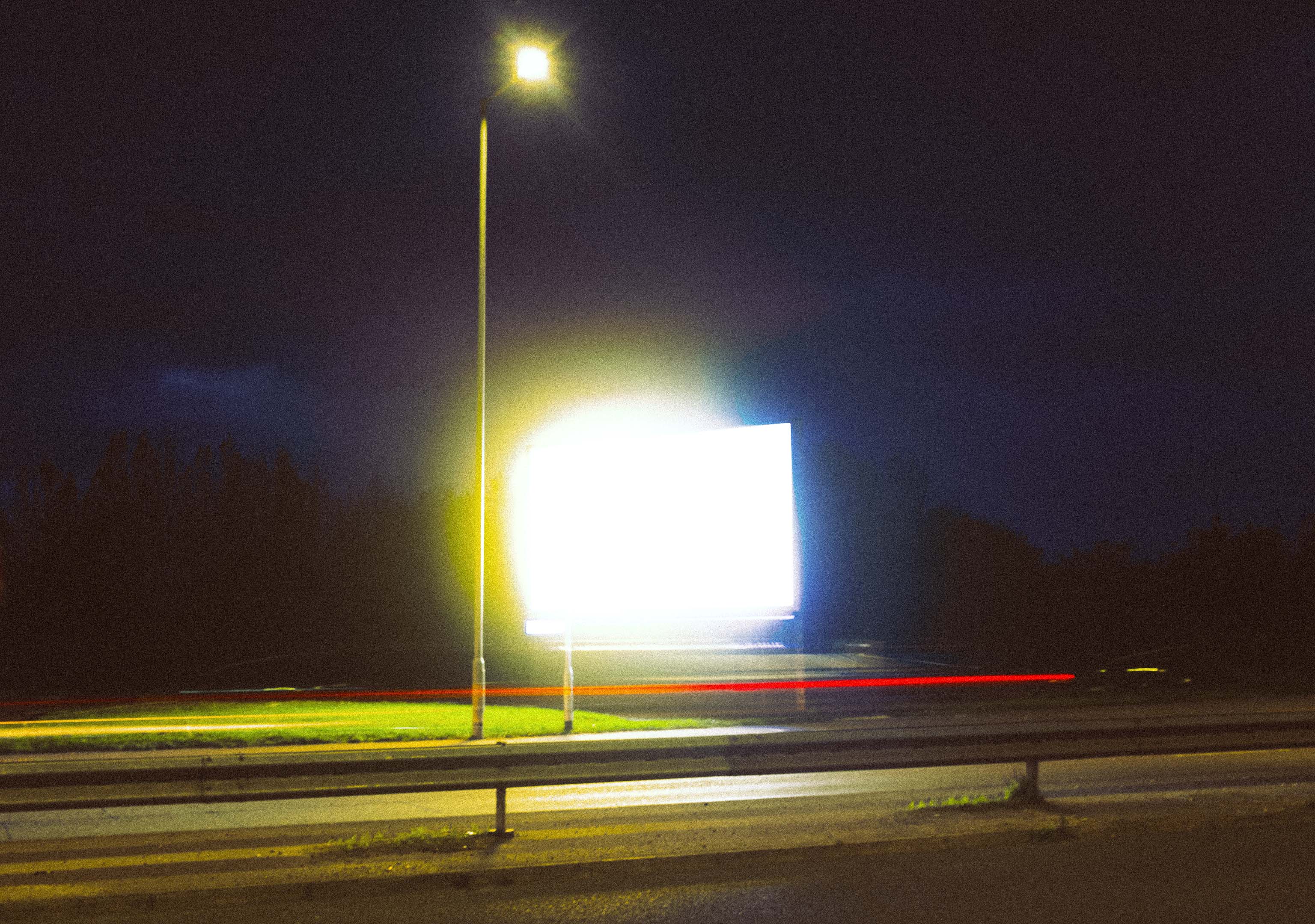 An advertisement sign taken at night for a long exposure creates a yellow and blue abstract image. Taken on the Fujifilm X100VI by Connor Redmond.